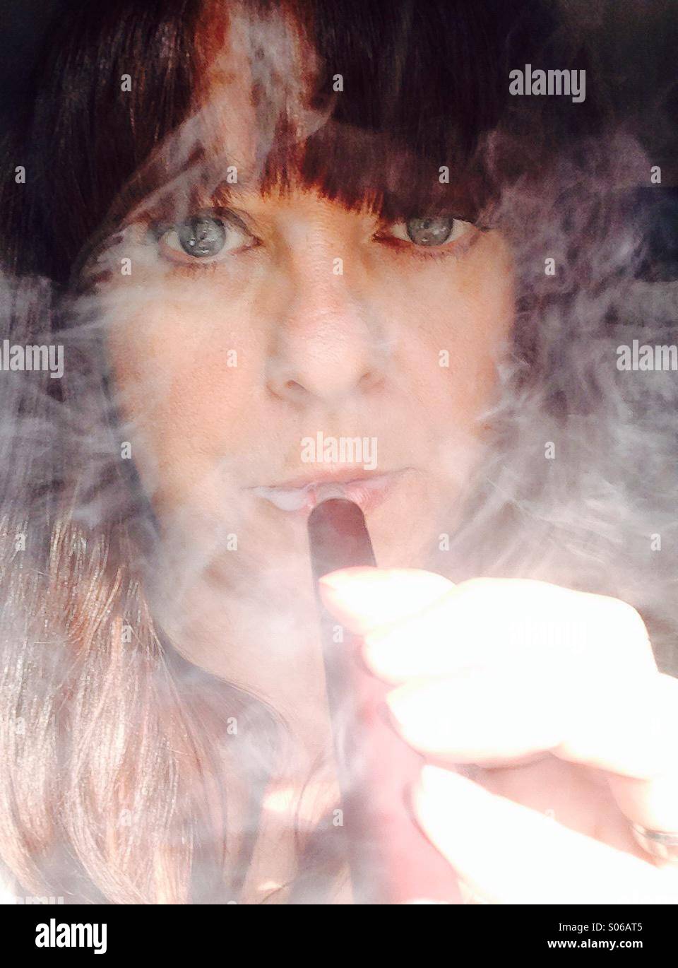 Woman smoking an E cigarette shisha pen. (Selfie) Stock Photo