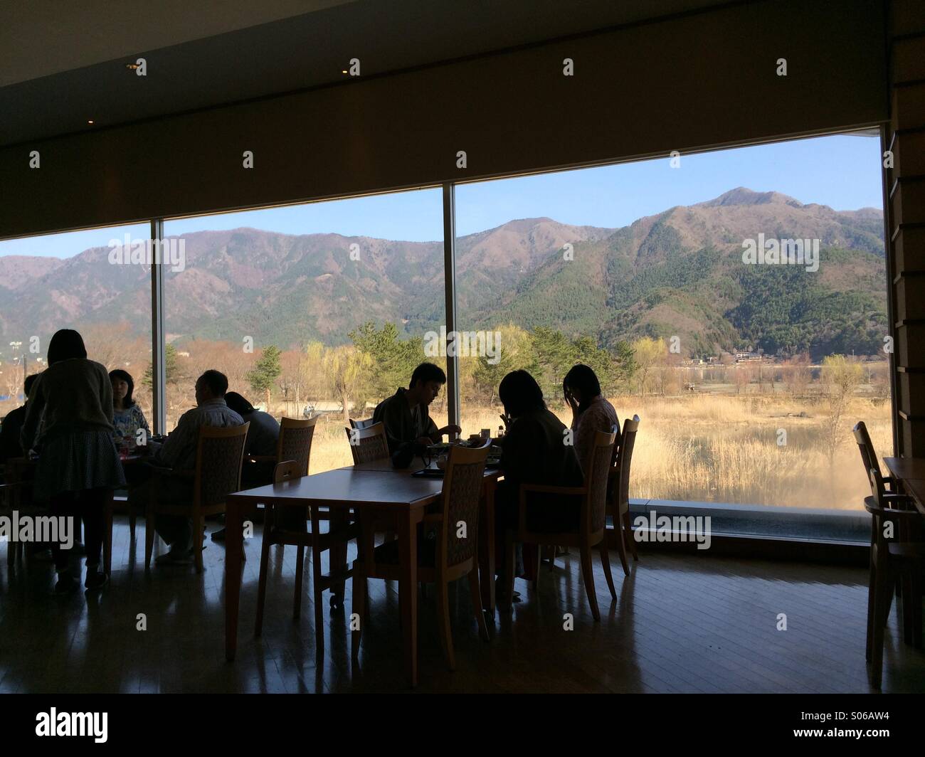 People having breakfast at a restaurant of ryokan hotel in Fujikawaguchiko, Japan with mountain view behind the windows. Spring 2014. Stock Photo