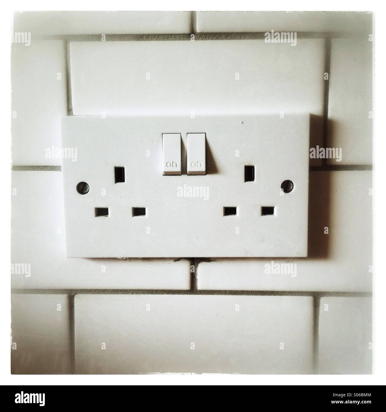 Double plug socket on a tiled wall - Smartphone Captured Stock Image