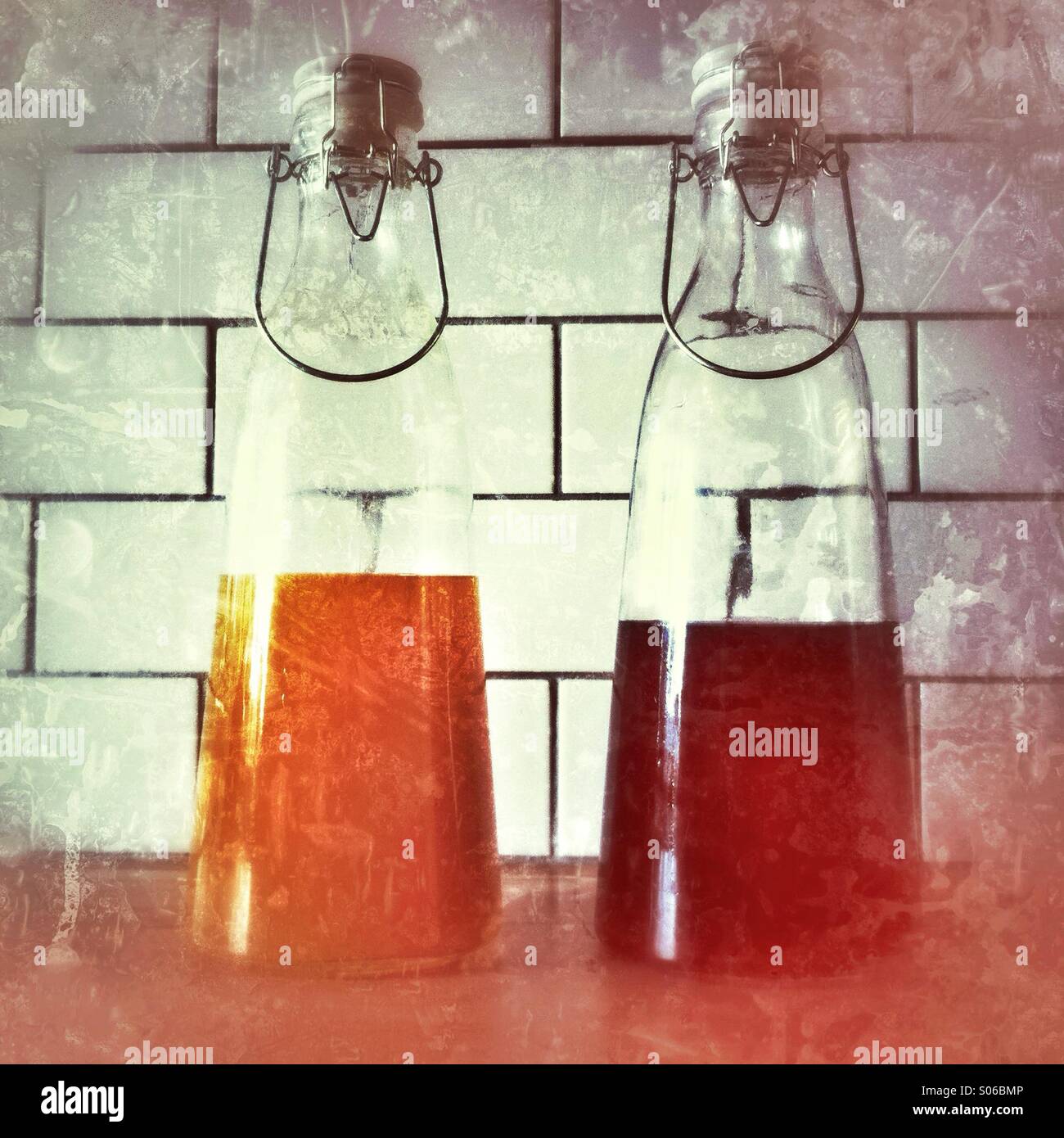 Bottles of juice cordial  against a tiled background in a cozy kitchen setting - Smartphone Captured Stock Image