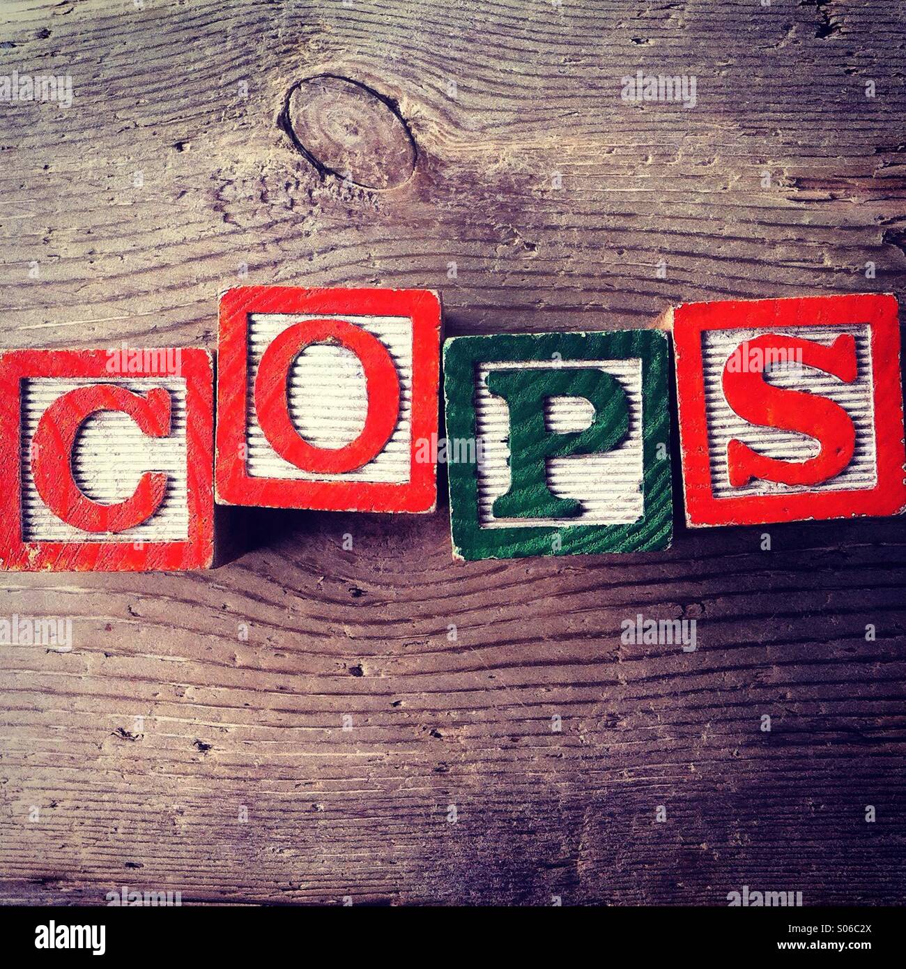 It's a photo of Woodblocks toy games with alphabet letters on them wich combine together to form the word COPS - Smartphone Captured Stock Image