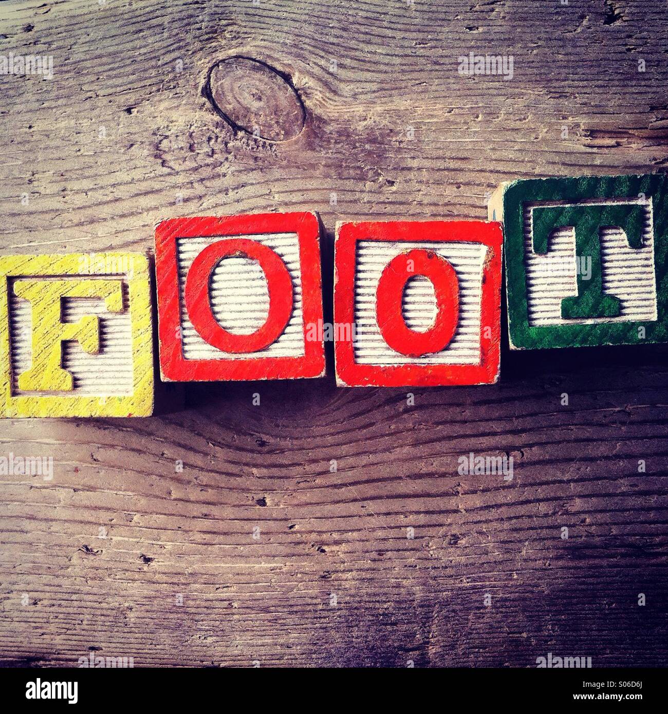 It's a photo of woodblocks toy with alphabet letters on them that are combined together to form the word FOOT - Smartphone Captured Stock Image