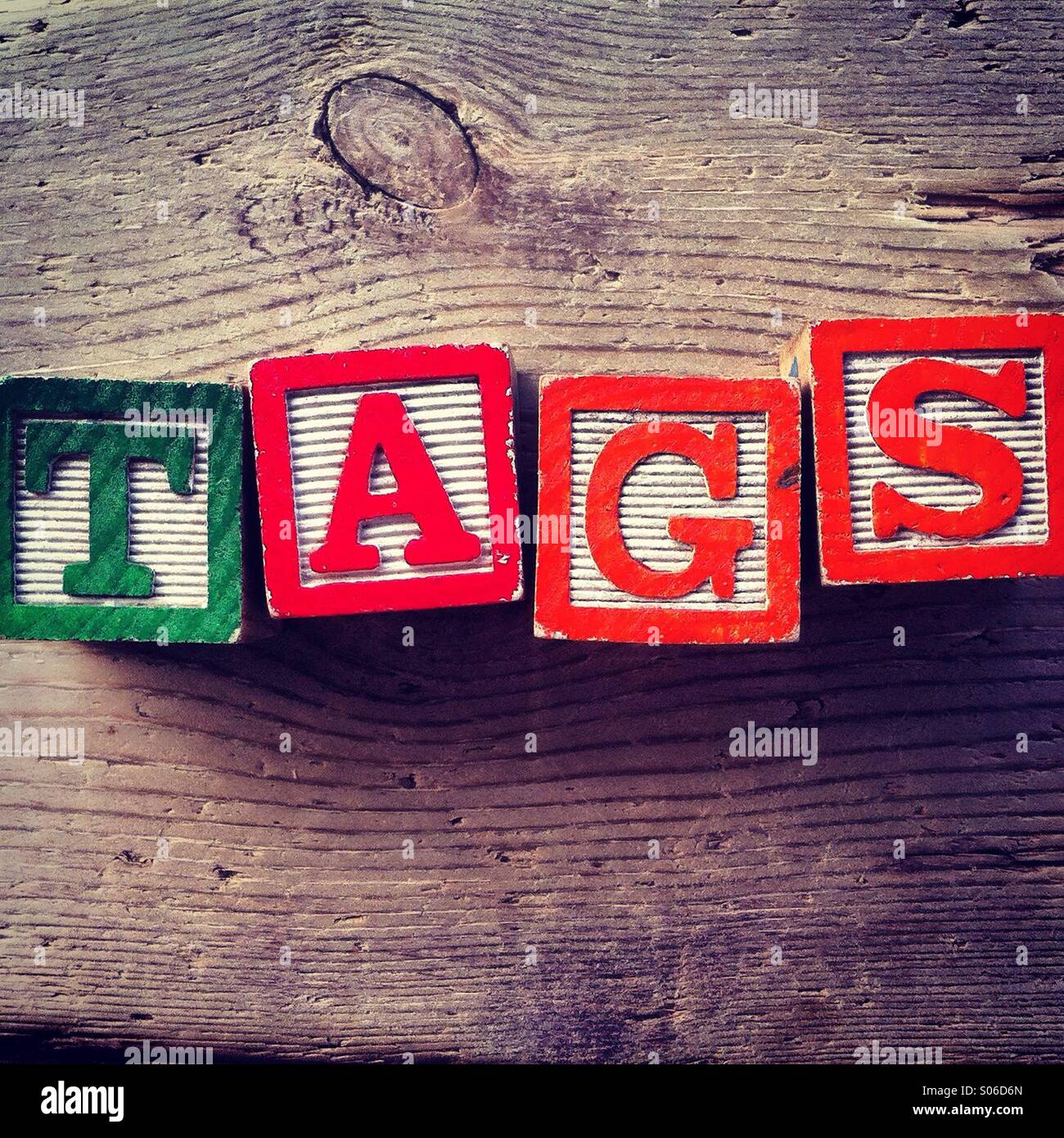 It's a photo of woodblocks toy with alphabet letters on them that are combined together to form the word TAGS - Smartphone Captured Stock Image
