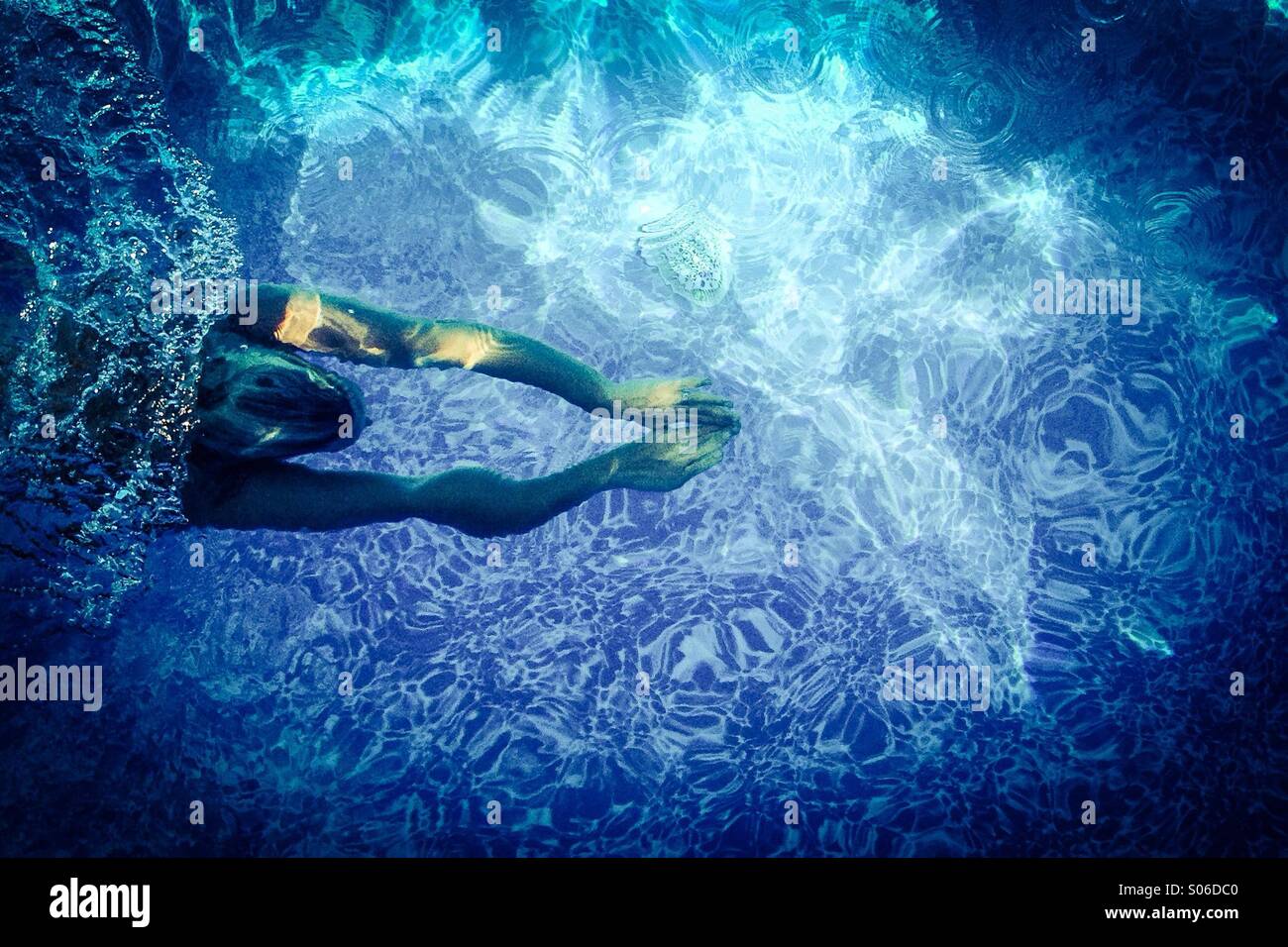 Woman swimming in pool, under water. Stock Photo