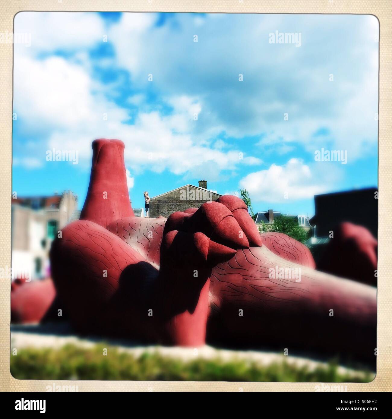 A girl plays on top of a giant sculpture representing an aardvark. This sculpture was a gift from the zoo to the city of Arnhem. - Smartphone Captured Stock Image