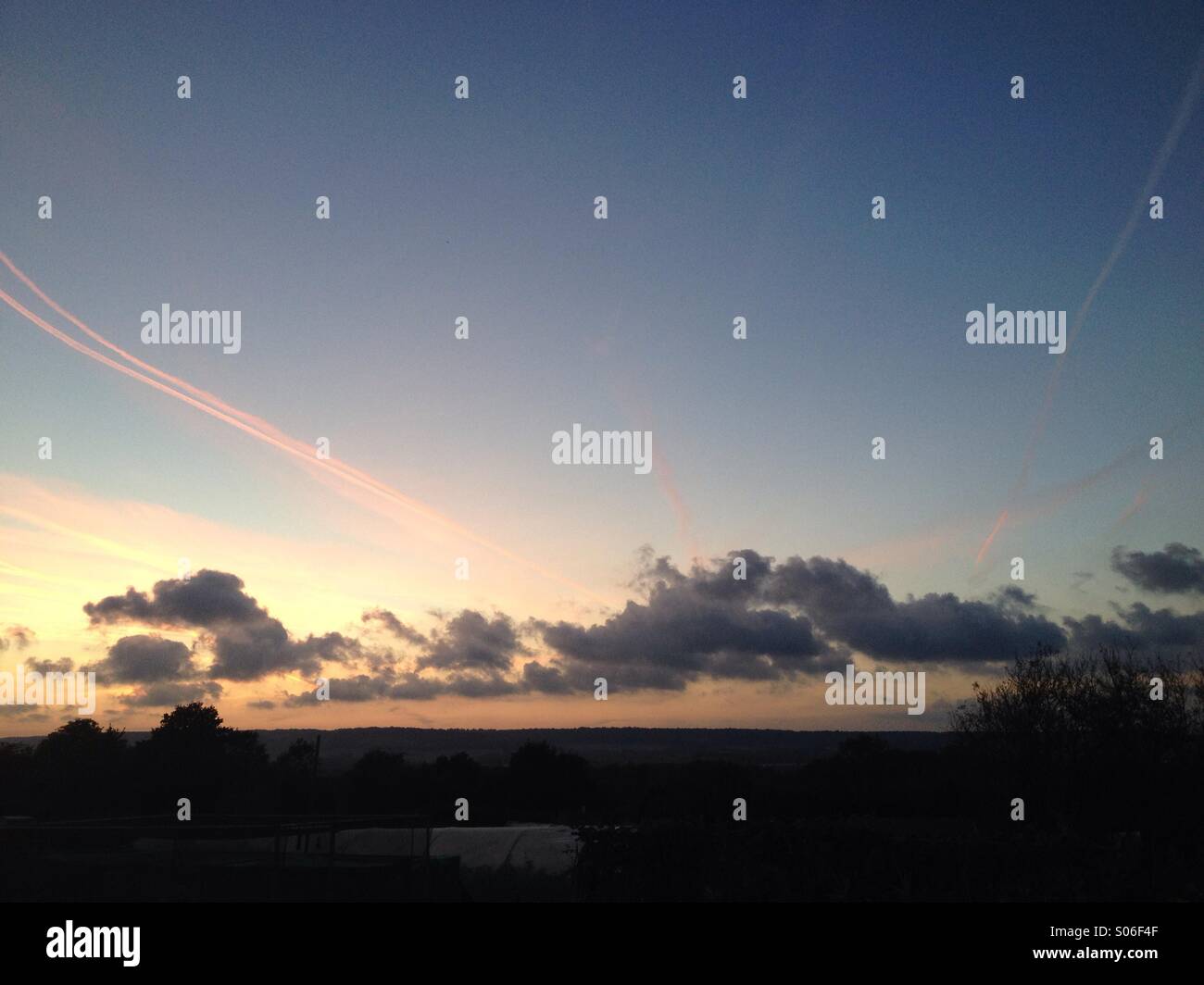 Pink dusk airplane vapour trails - Smartphone Captured Stock Image