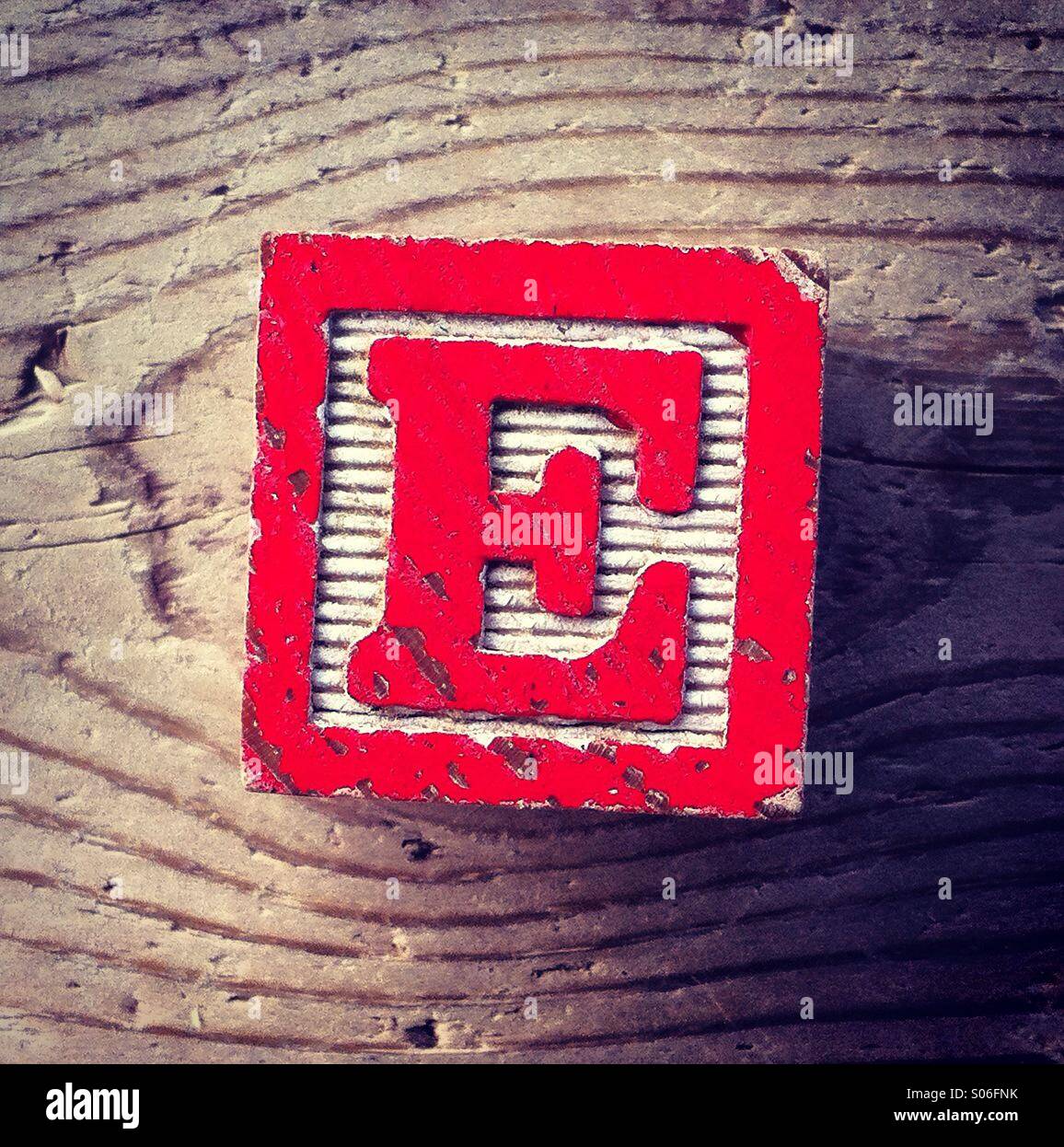 It's a woodblock toy with an alphabet letter on it: E - Smartphone Captured Stock Image