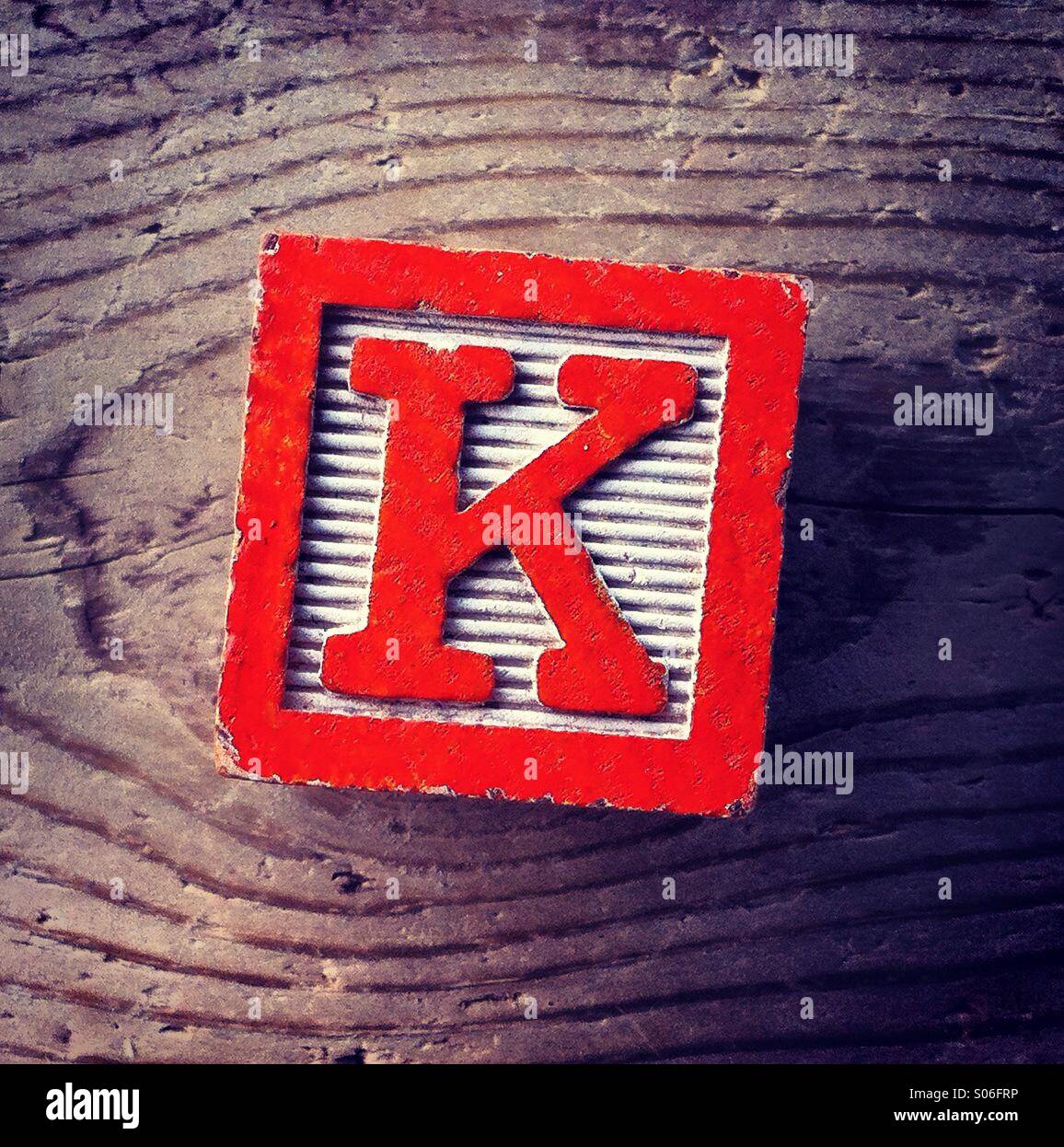 It's a woodblock toy with an alphabet letter on it: K Stock Photo