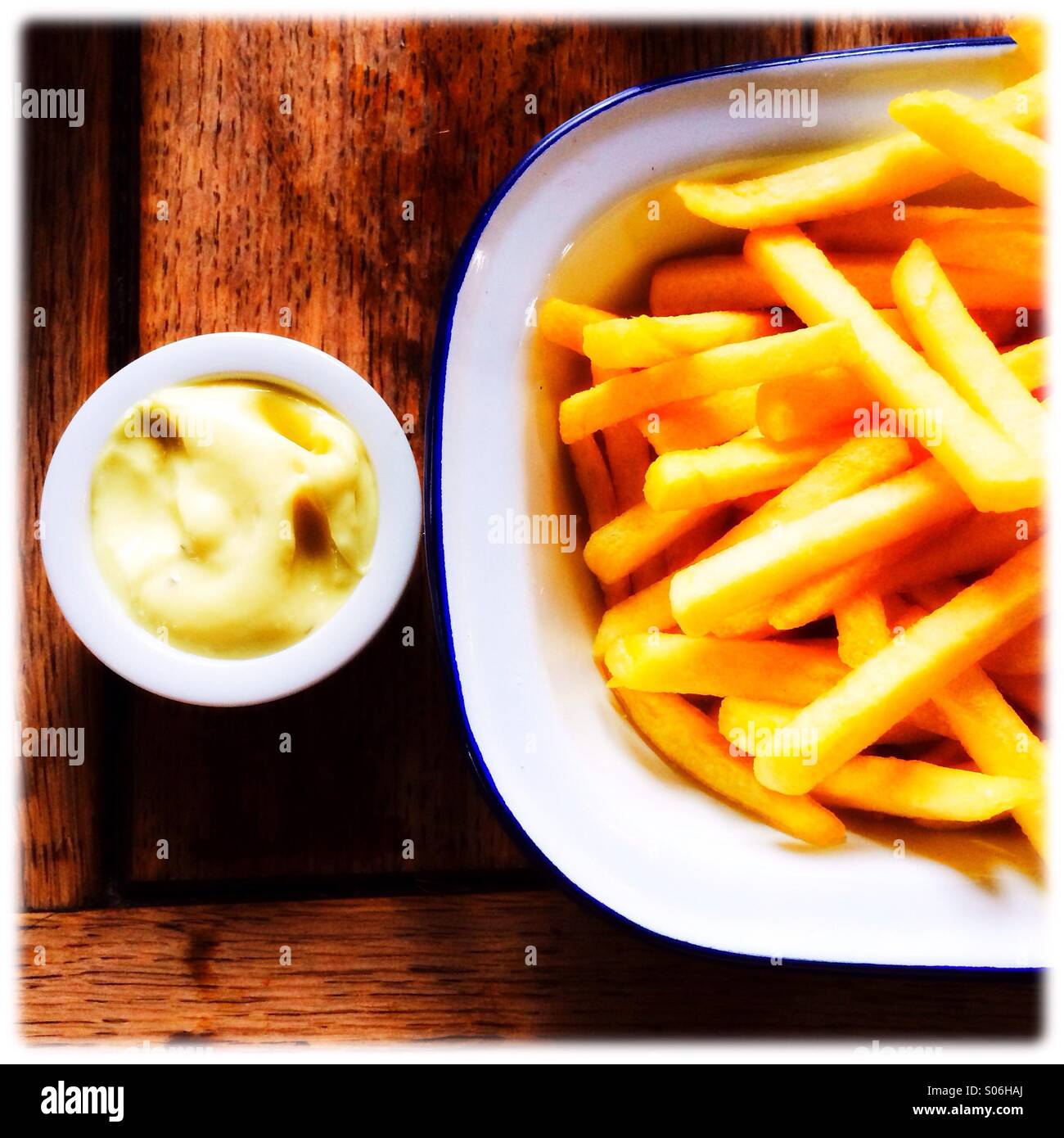A plate of French fries with a sauce dip Stock Photo