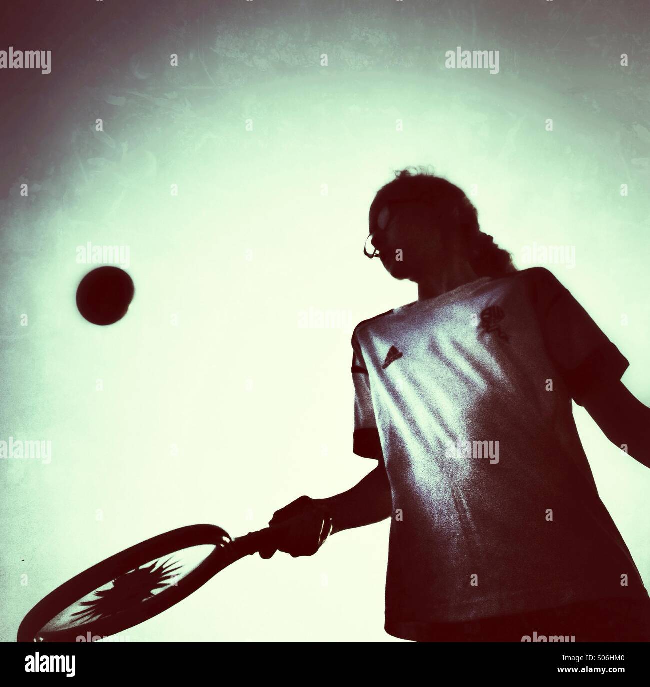 High contrast image of girl bouncing ball on toy racket - Smartphone Captured Stock Image