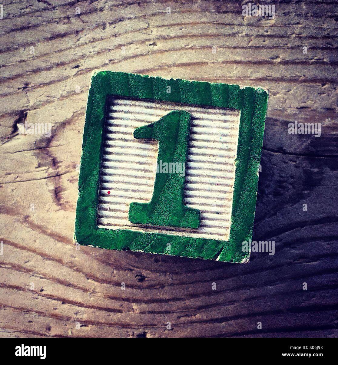 It's a photo of a woodblock toy with a number on it : 1 - Smartphone Captured Stock Image