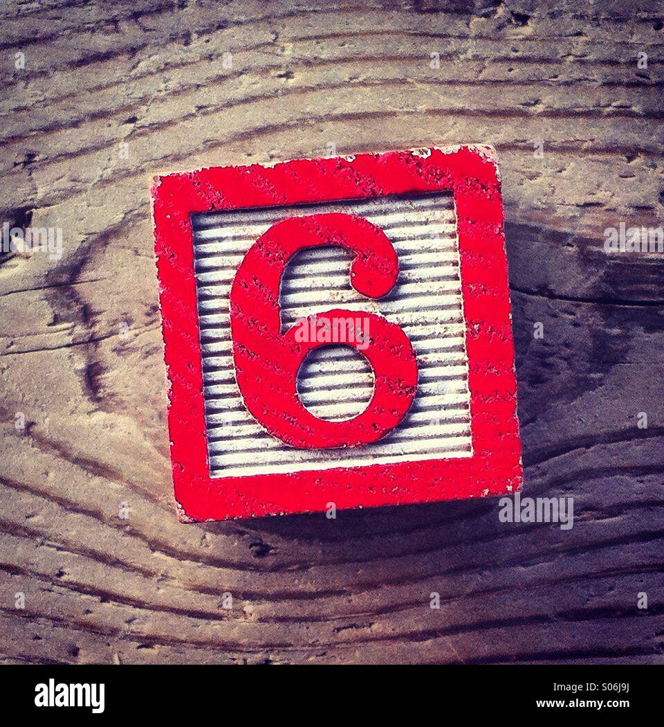 It's a photo of a woodblock toy with a number on it : 6 - Smartphone Captured Stock Image