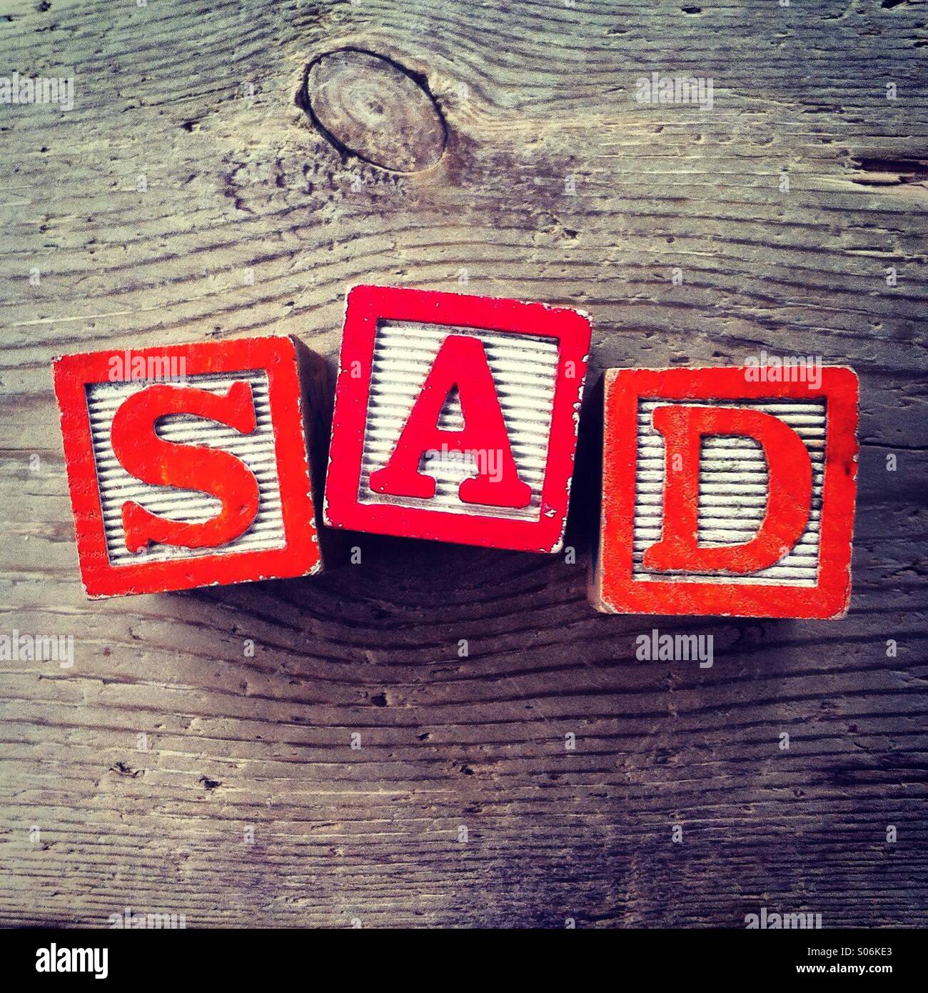 It's a photo of woodblocks toys will alphabet letter on them which are combines together to create the word SAD - Smartphone Captured Stock Image