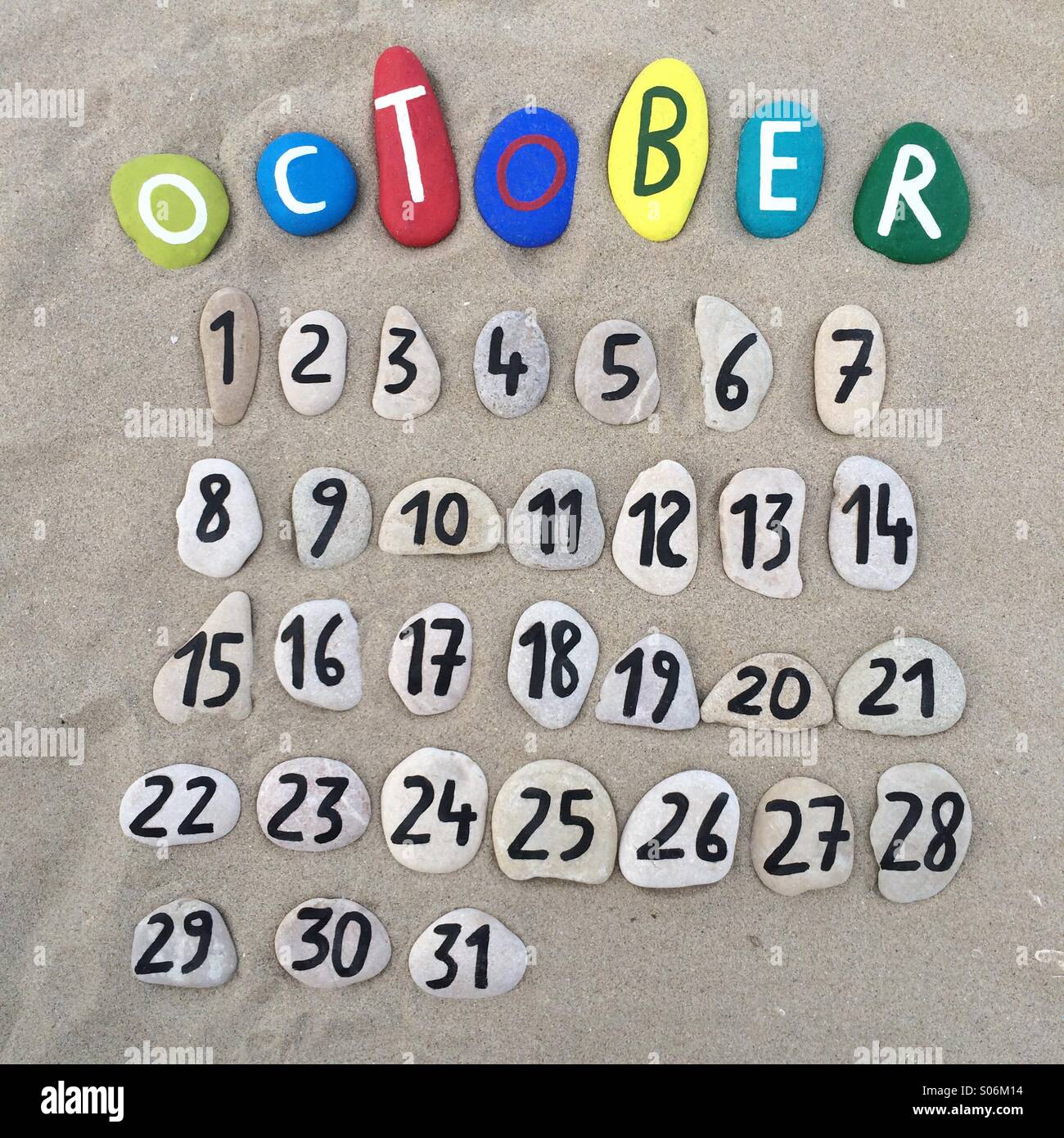 October month calendar with stones composition on the sand - Smartphone Captured Stock Image