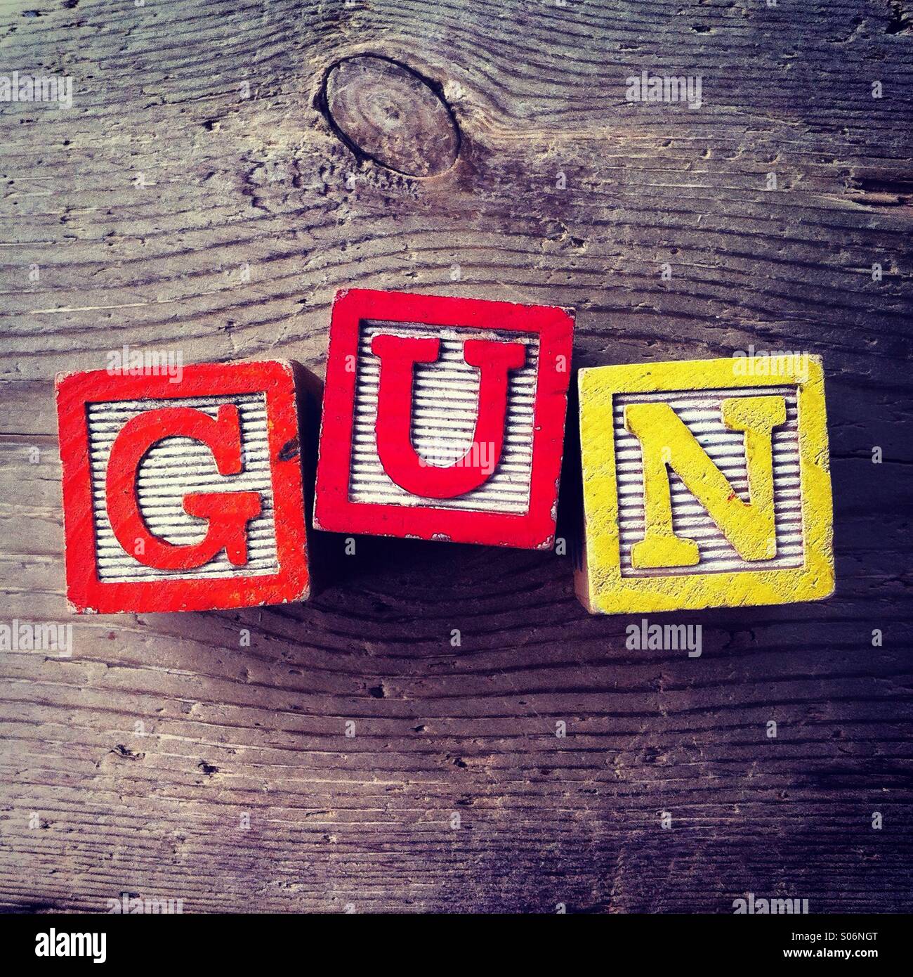 It's a photo of woodblocks toys will alphabet letter on them which are combines together to create the word GUN - Smartphone Captured Stock Image