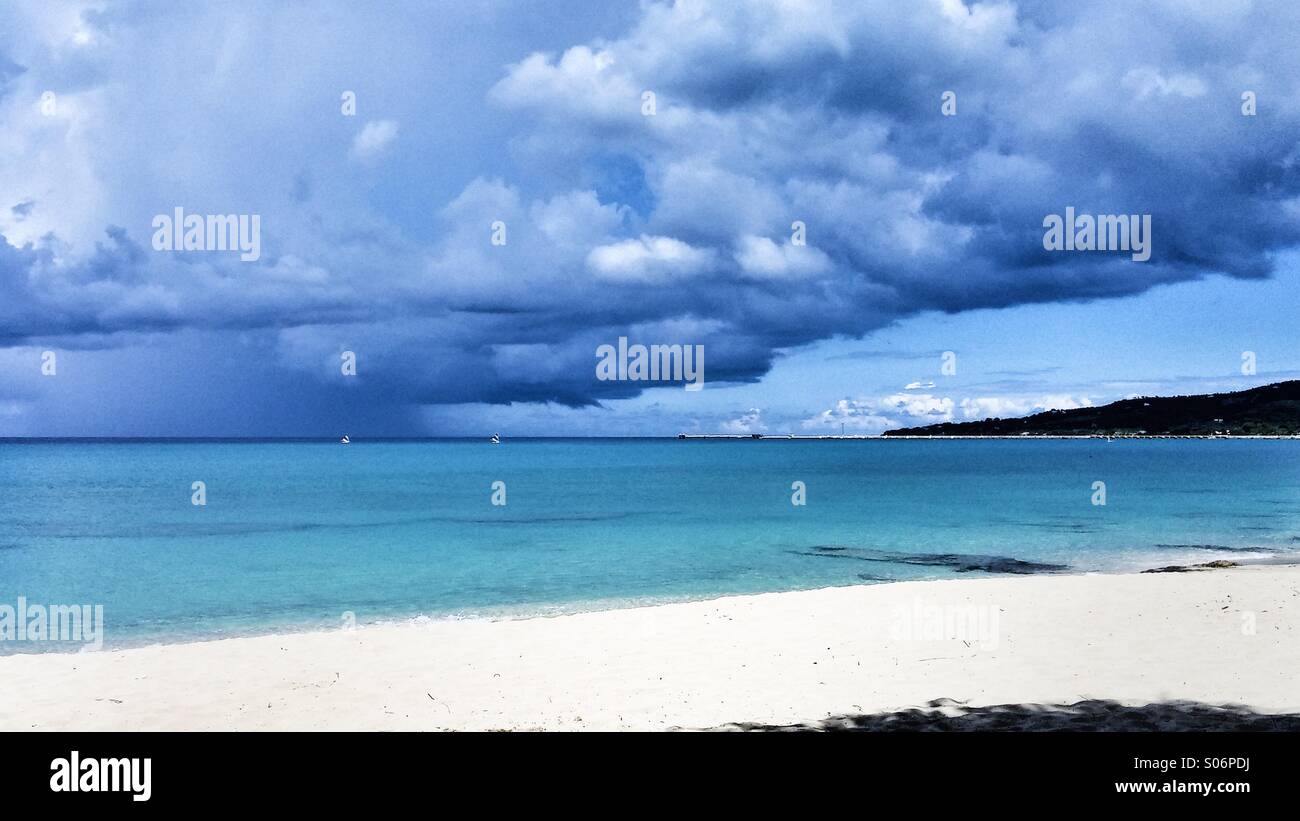 A storm gathers off the island of St. Croix, U.S.Virgin Islands, west end, while two small sailboats race to port. - Smartphone Captured Stock Image