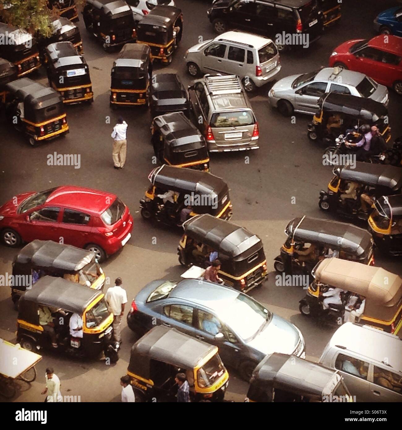 A traffic police man in between traffic in all directions in Mumbai , India Stock Photo