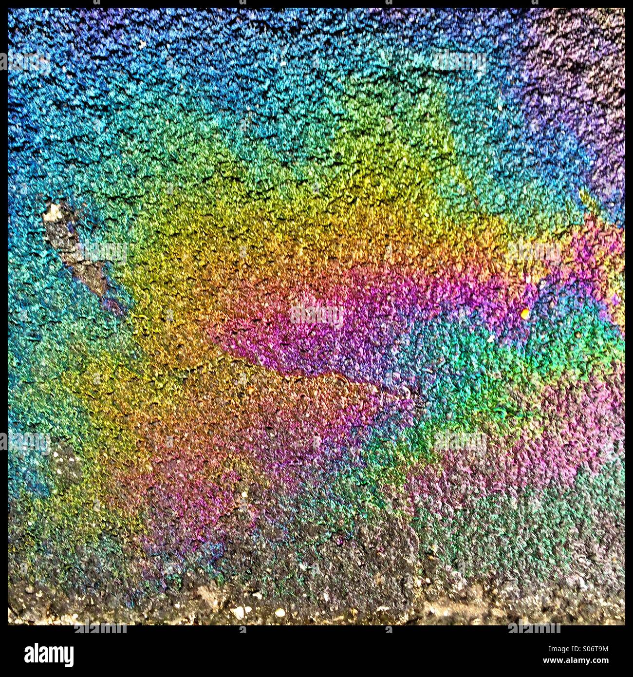 Oil spill on the ground next to a car. - Smartphone Captured Stock Image