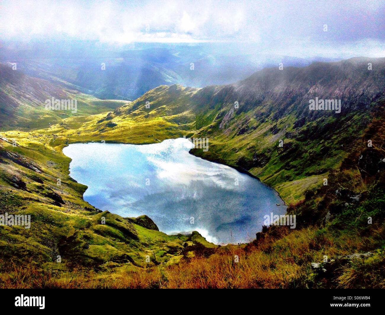 Llyn Cau seen on the way up Cadair Idris. Clouds reflected in the lake. Stock Photo