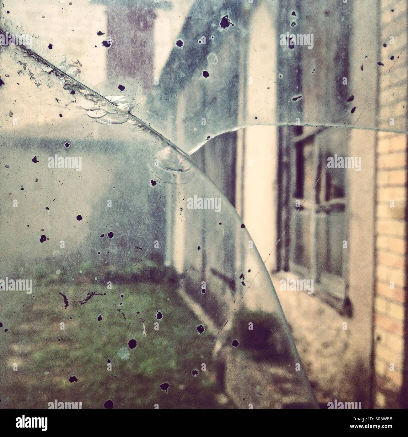 An old facade viewed through a broken glass Stock Photo