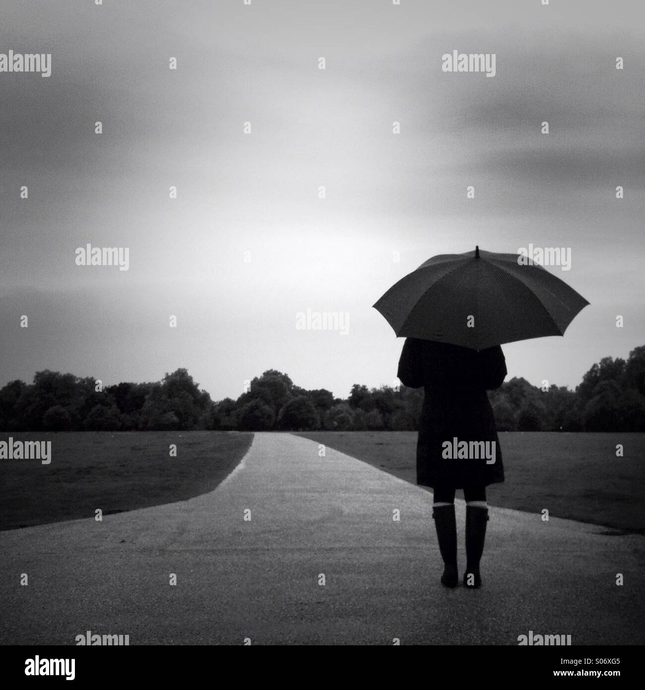 A women stands in Hyde Park on a rainy day. London, England UK. - Smartphone Captured Stock Image