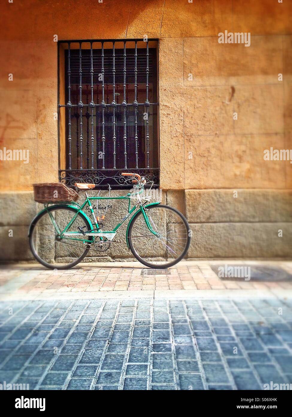 Bicycle leaning against wall under ornate window, Madrid, Spain Stock Photo