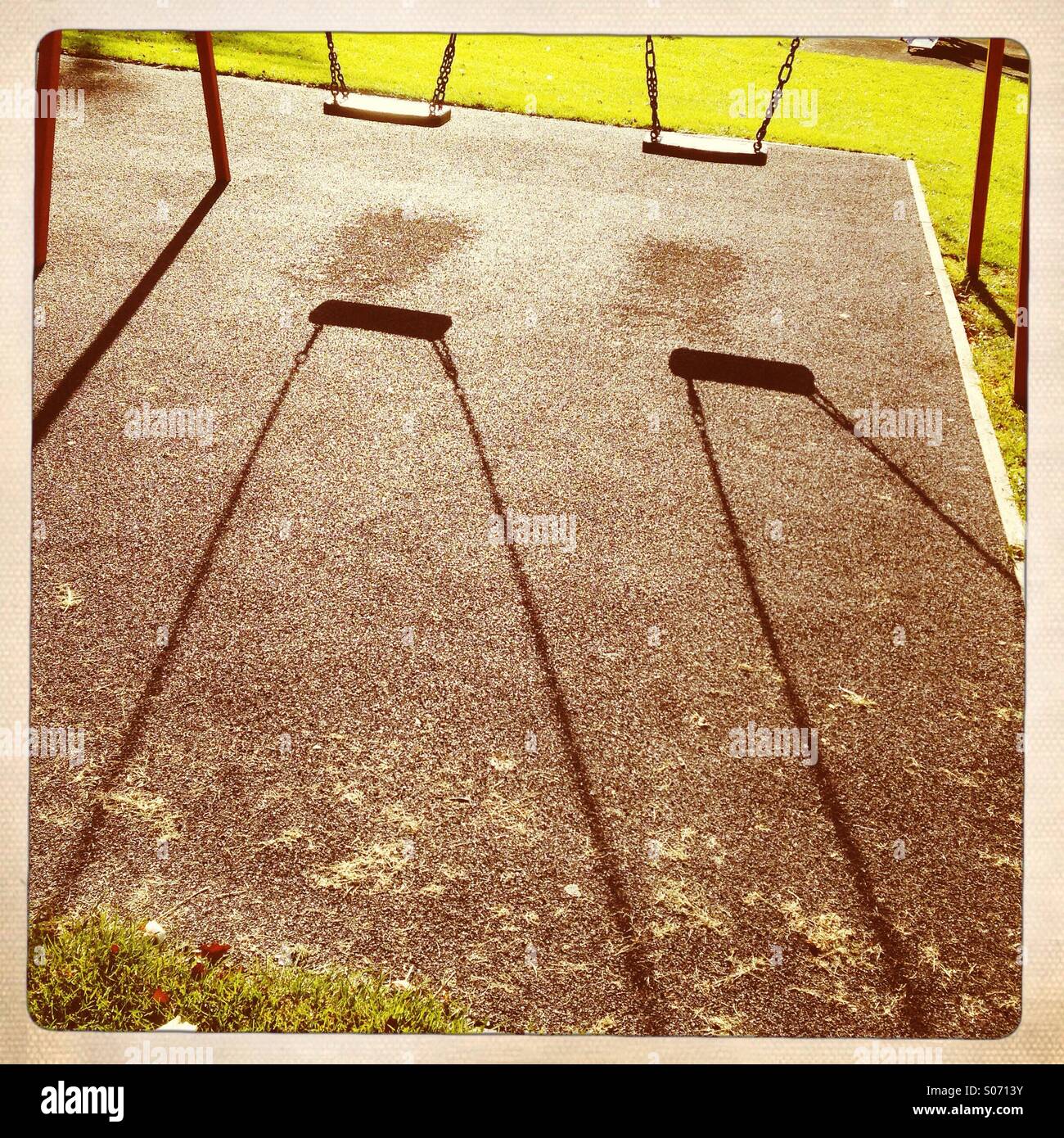 Shadows of swings in a children's play park. UK - Smartphone Captured Stock Image