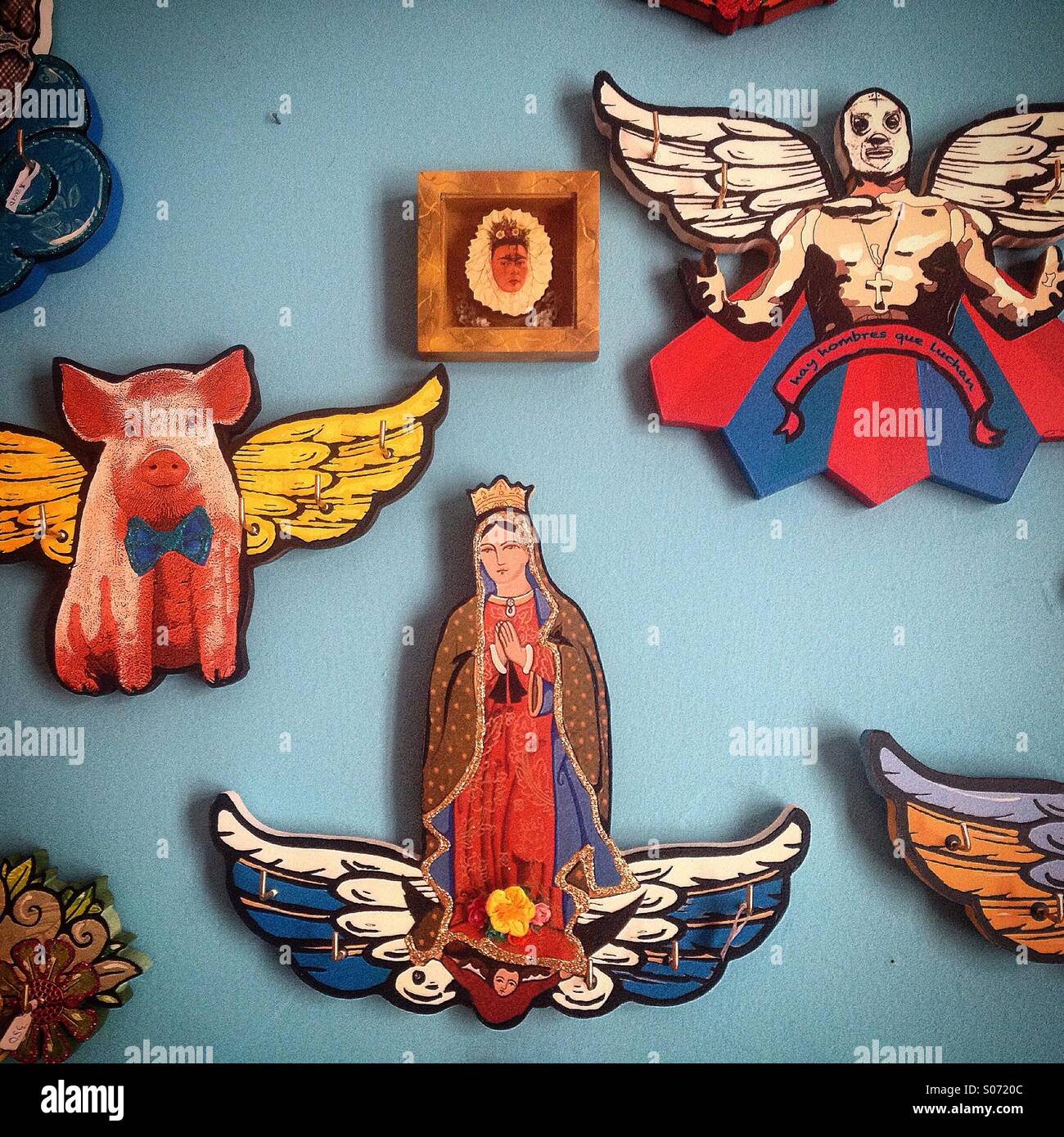 Images of Our Lady of Guadalupe, a pig and a free fight luchador with wings decorate 'La luna de Romelia' folk art studio in Mexico City, Mexico - Smartphone Captured Stock Image