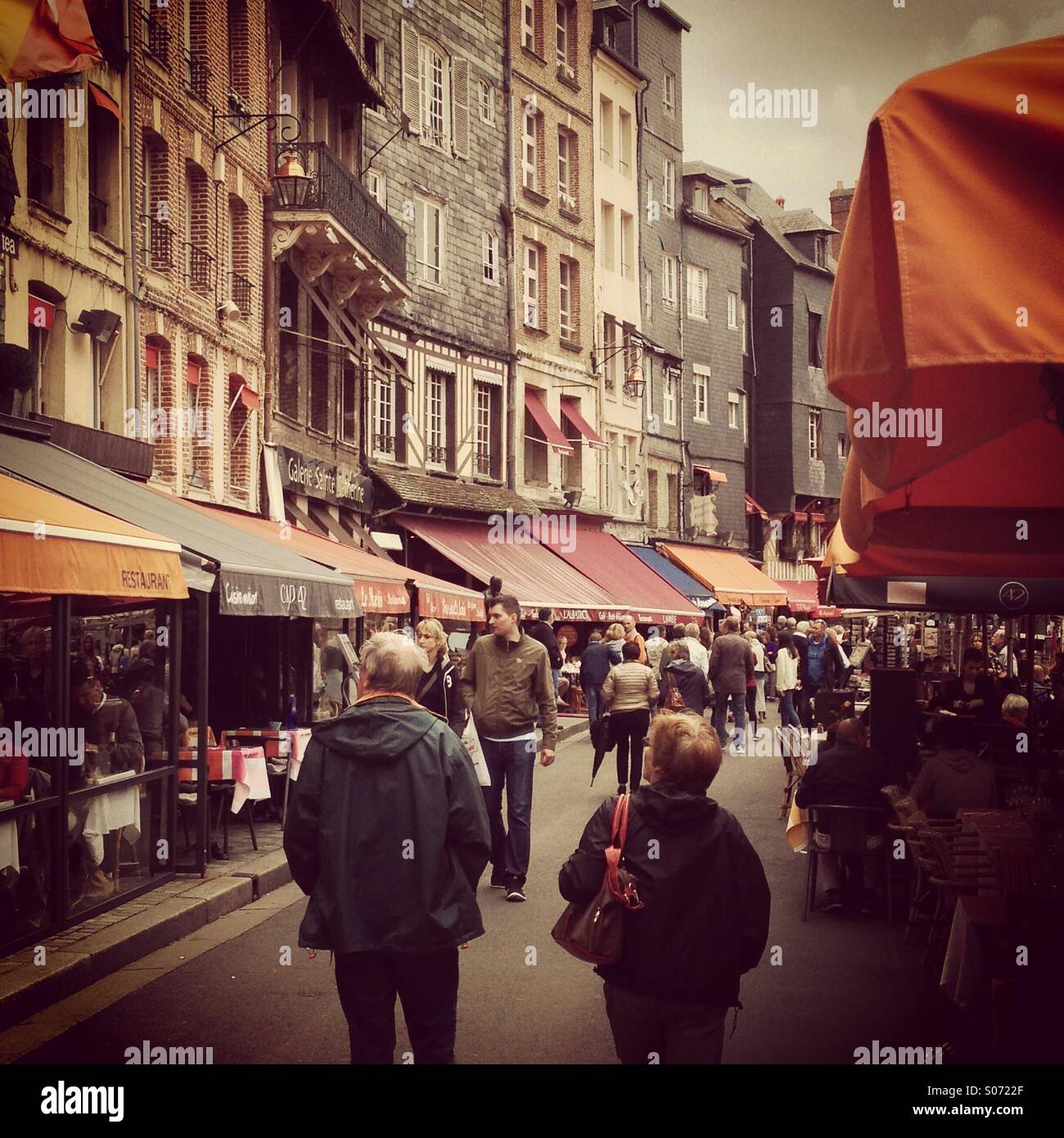 Busy restaurants line the harbour at Honfleur, Normandy, France. Instagram style iPhone mobile phone photo. - Smartphone Captured Stock Image
