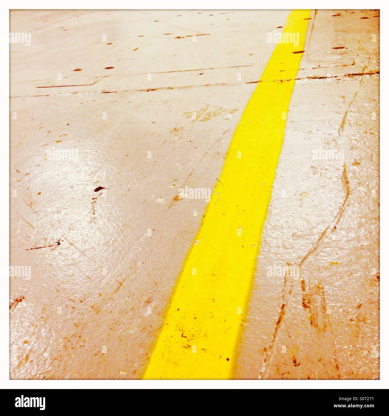 Yellow stripe on a factory floor. Stock Photo