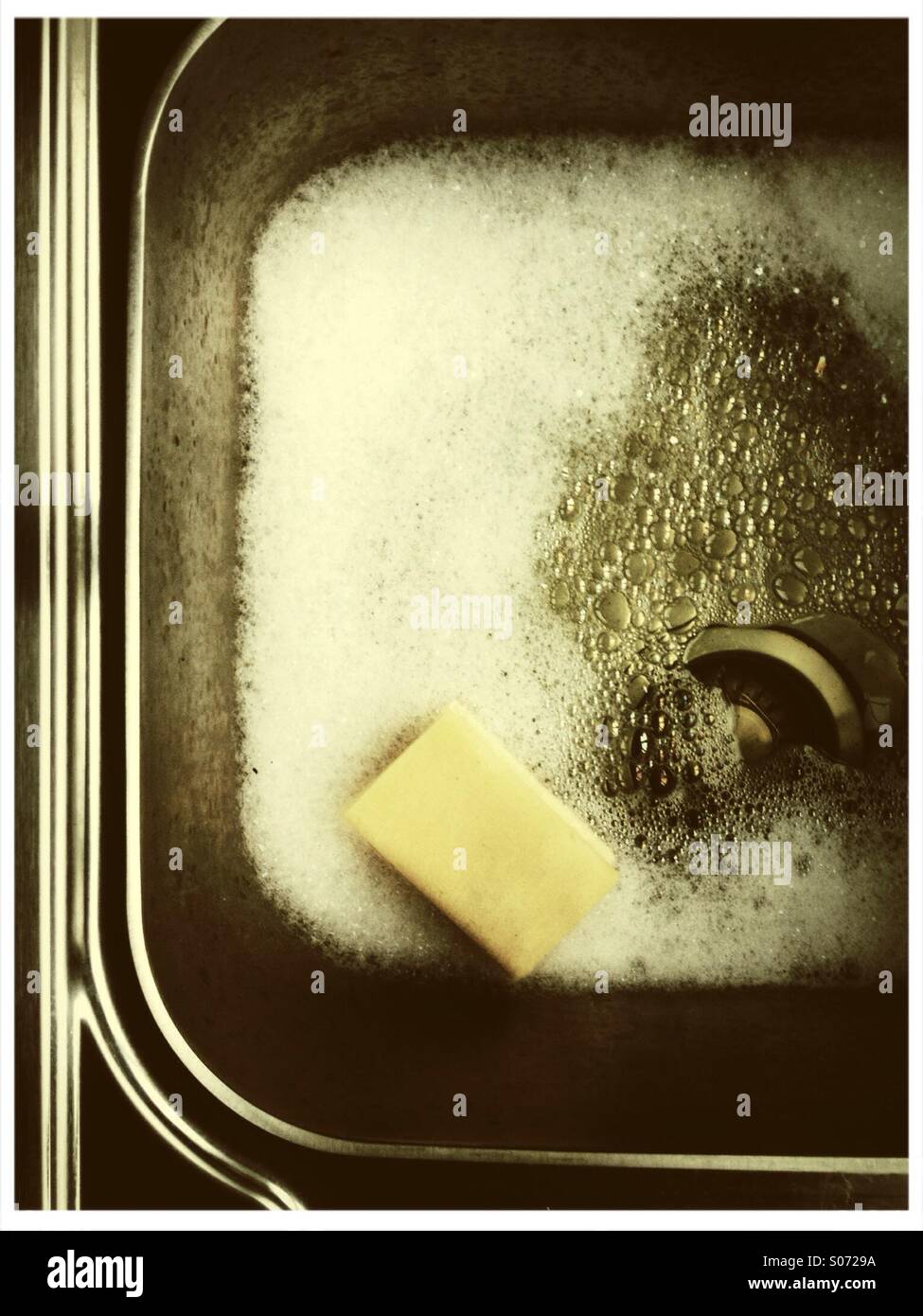 Sink with soap suds and nylon sponge Stock Photo