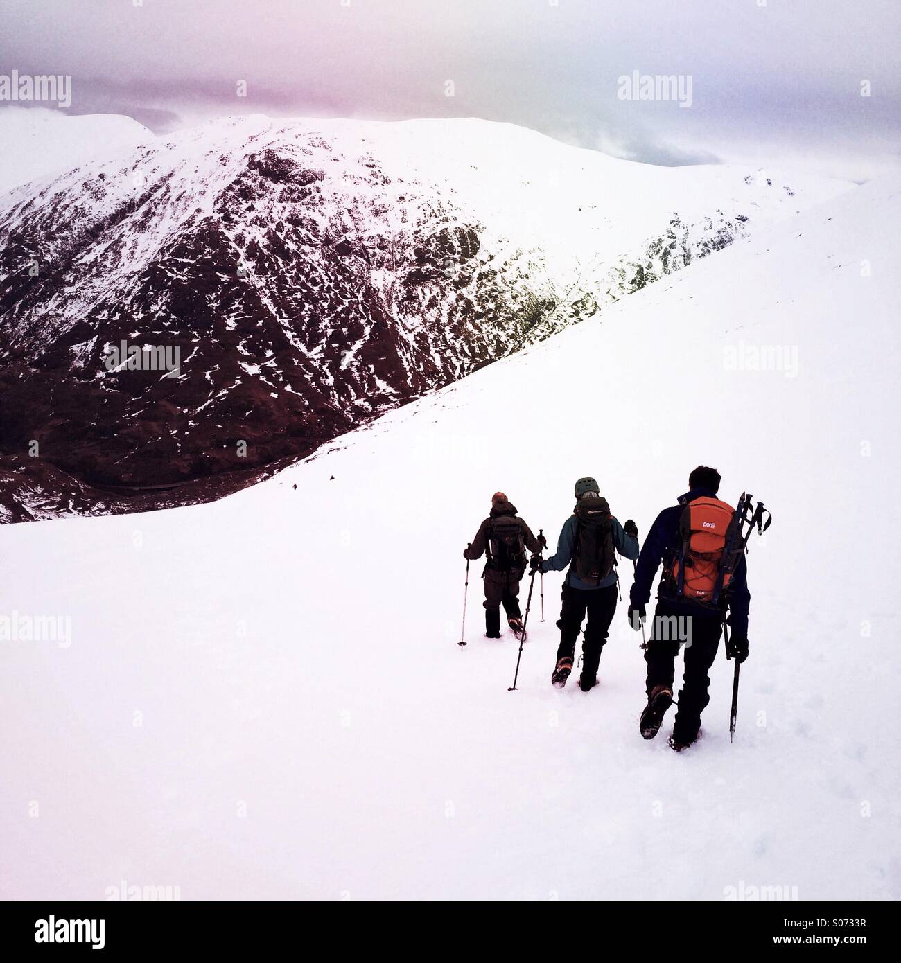 Mountaineers descend a snow slope in Glencoe in Scotland UK - Smartphone Captured Stock Image