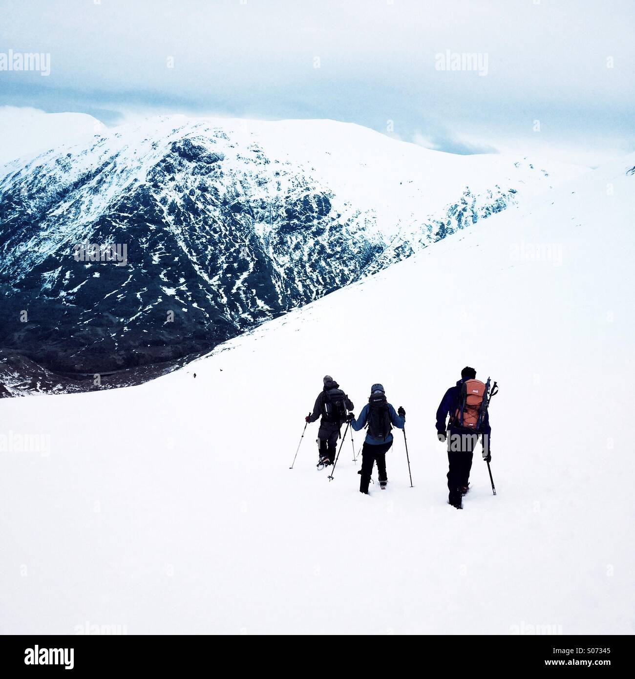 Three mountaineers descend a mountain in Glencoe Scotland - Smartphone Captured Stock Image