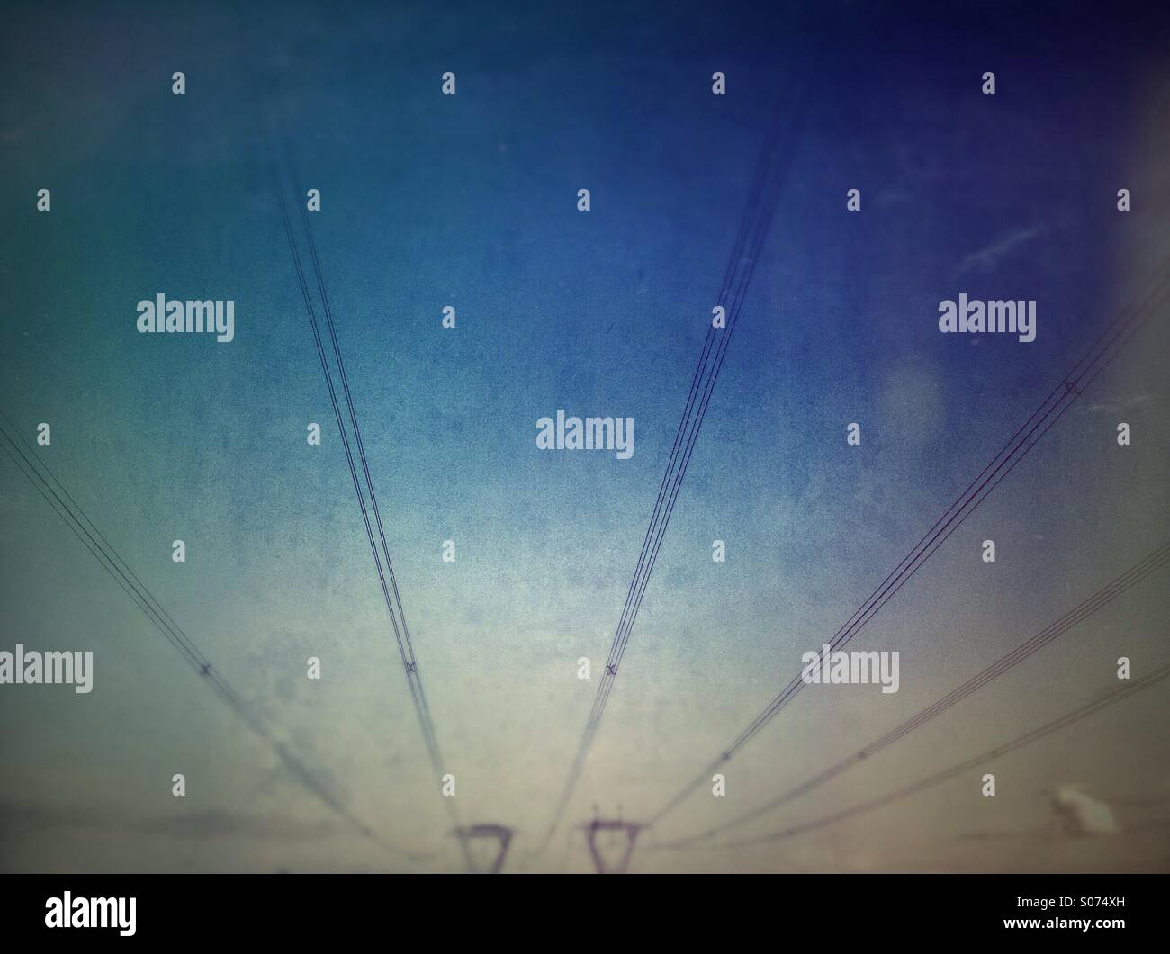 Power lines with blurred towers in background. - Smartphone Captured Stock Image