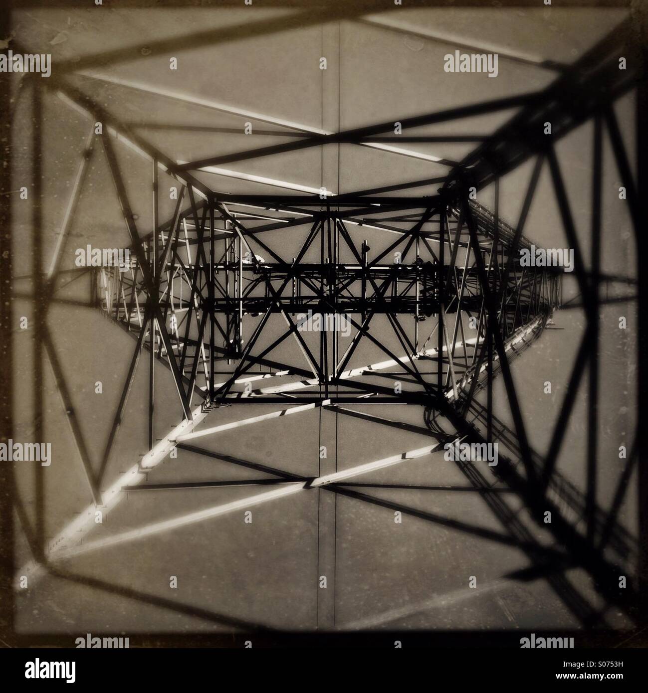 Looking straight up from the inside of a metal electrical tower. Stock Photo