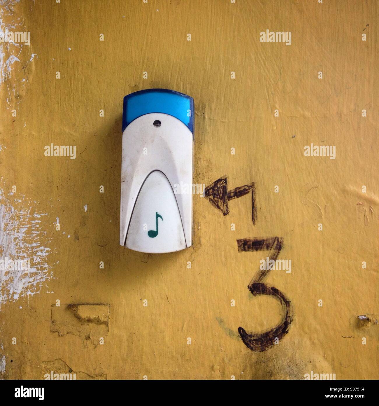 A number three and an arrow painted close to a door bell decorated with a musical note in Colonia Condesa, Mexico City, Mexico - Smartphone Captured Stock Image