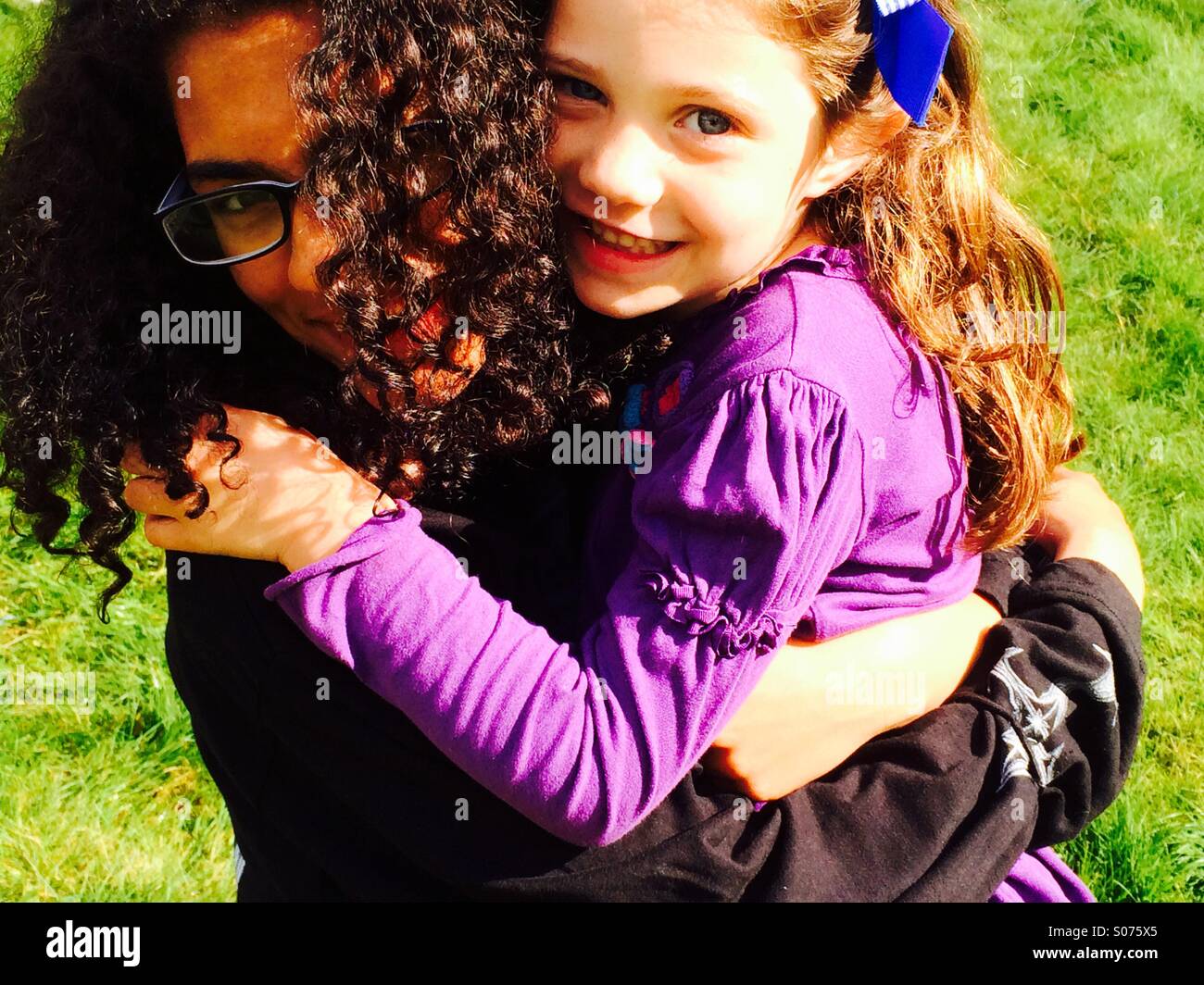 13 year old girl and 5 year old girl hugging Stock Photo