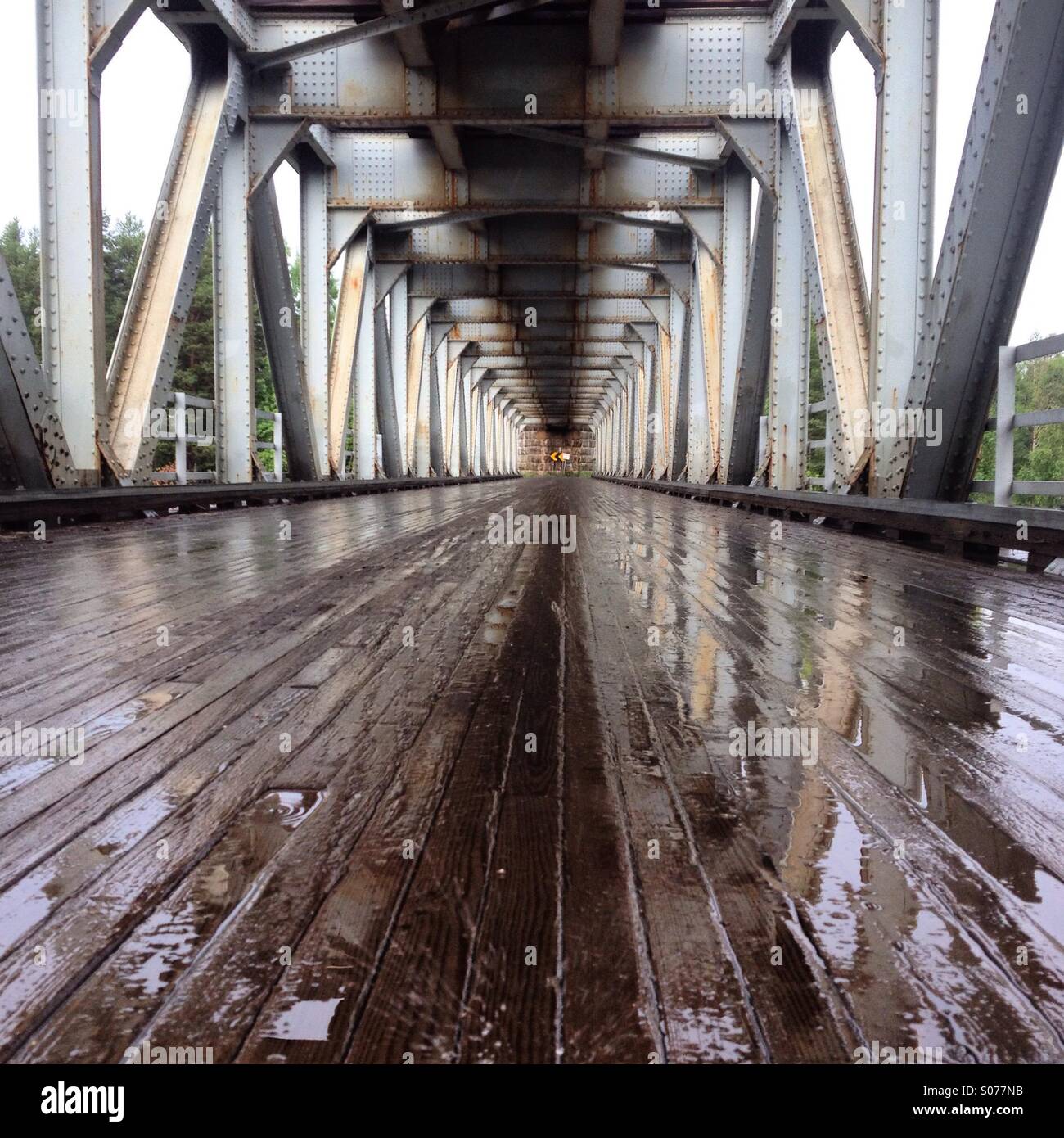 A rainy old fashioned railway bridge with wooden board underpass in a remote part of Northern Finland - Smartphone Captured Stock Image