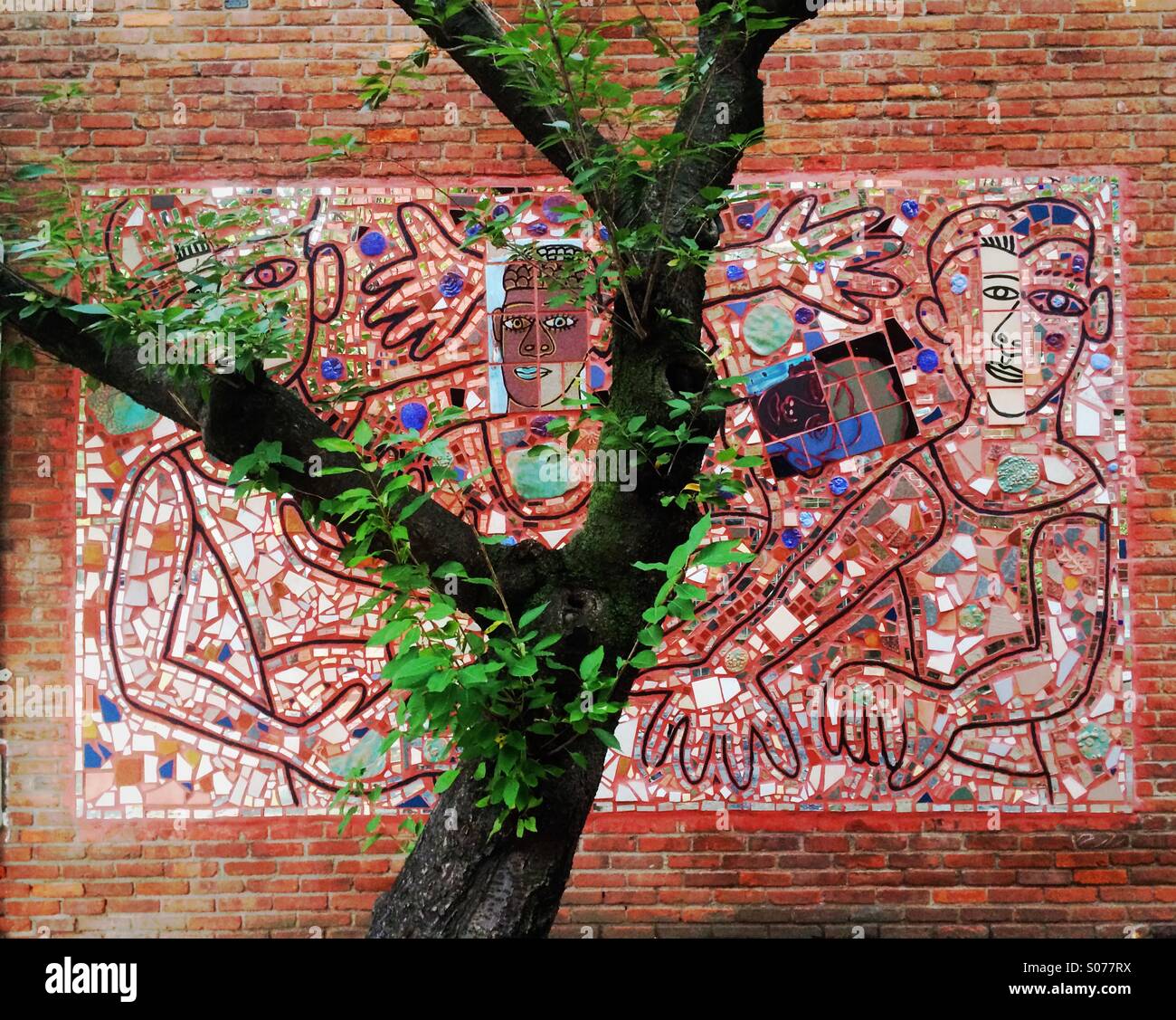 Mural on street in Philadelphia near Lombard St by Isaiah Zagar with tree - Smartphone Captured Stock Image