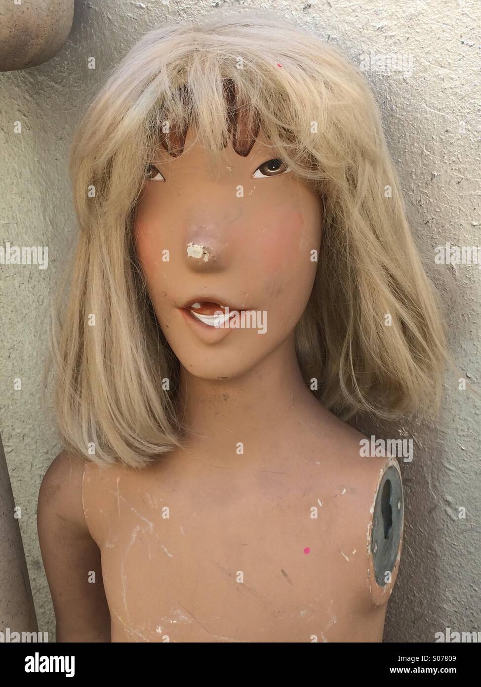 Funny looking vintage mannequin with blond hair smiling Stock Photo