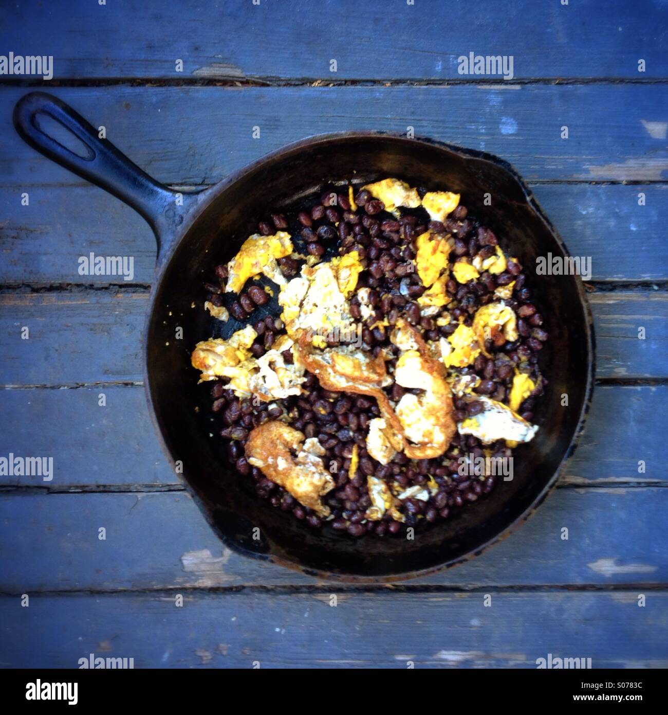 Black beans and eggs in an iron skillet Stock Photo - Alamy