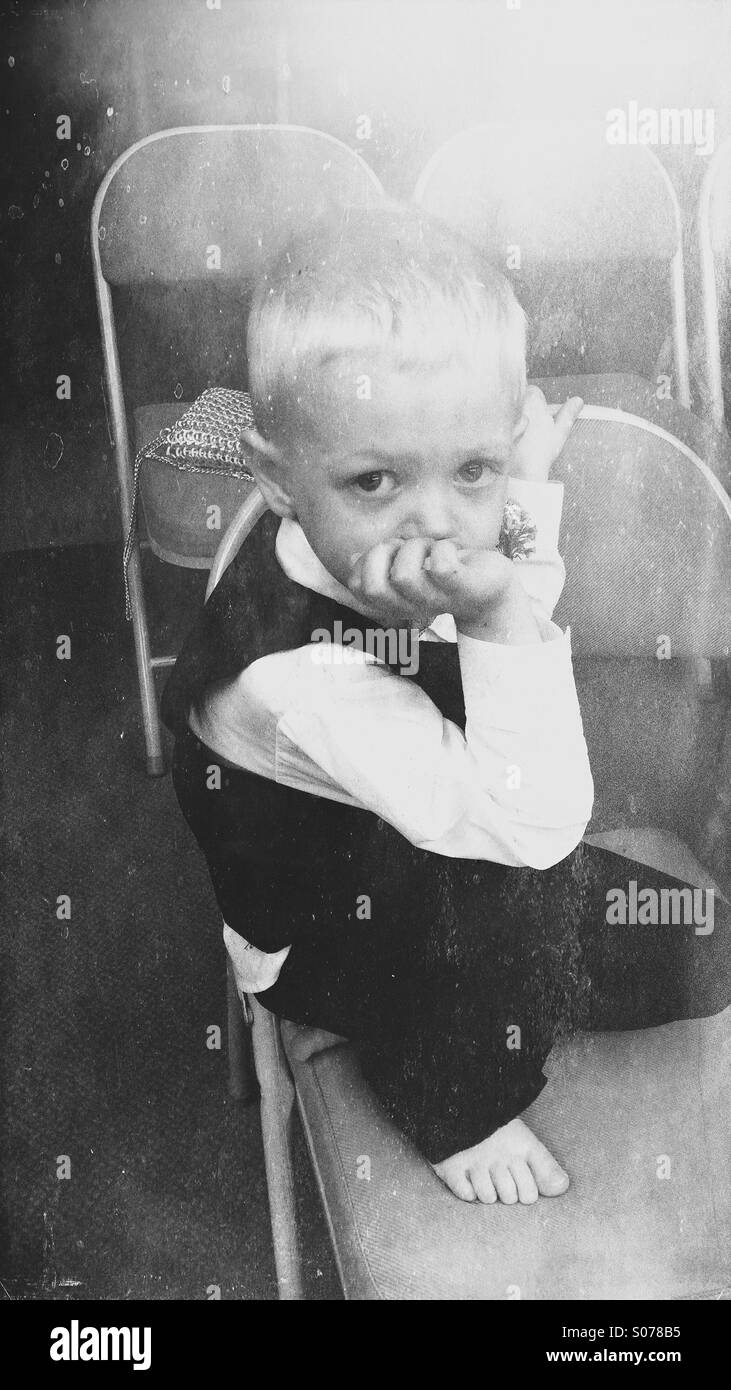 A small boy waiting to be ring-bearer in a wedding. - Smartphone Captured Stock Image
