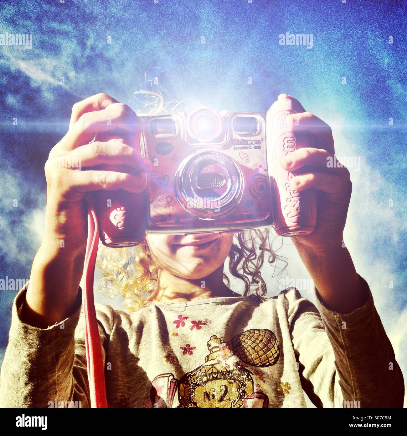 Young girl taking photo with toy camera Stock Photo