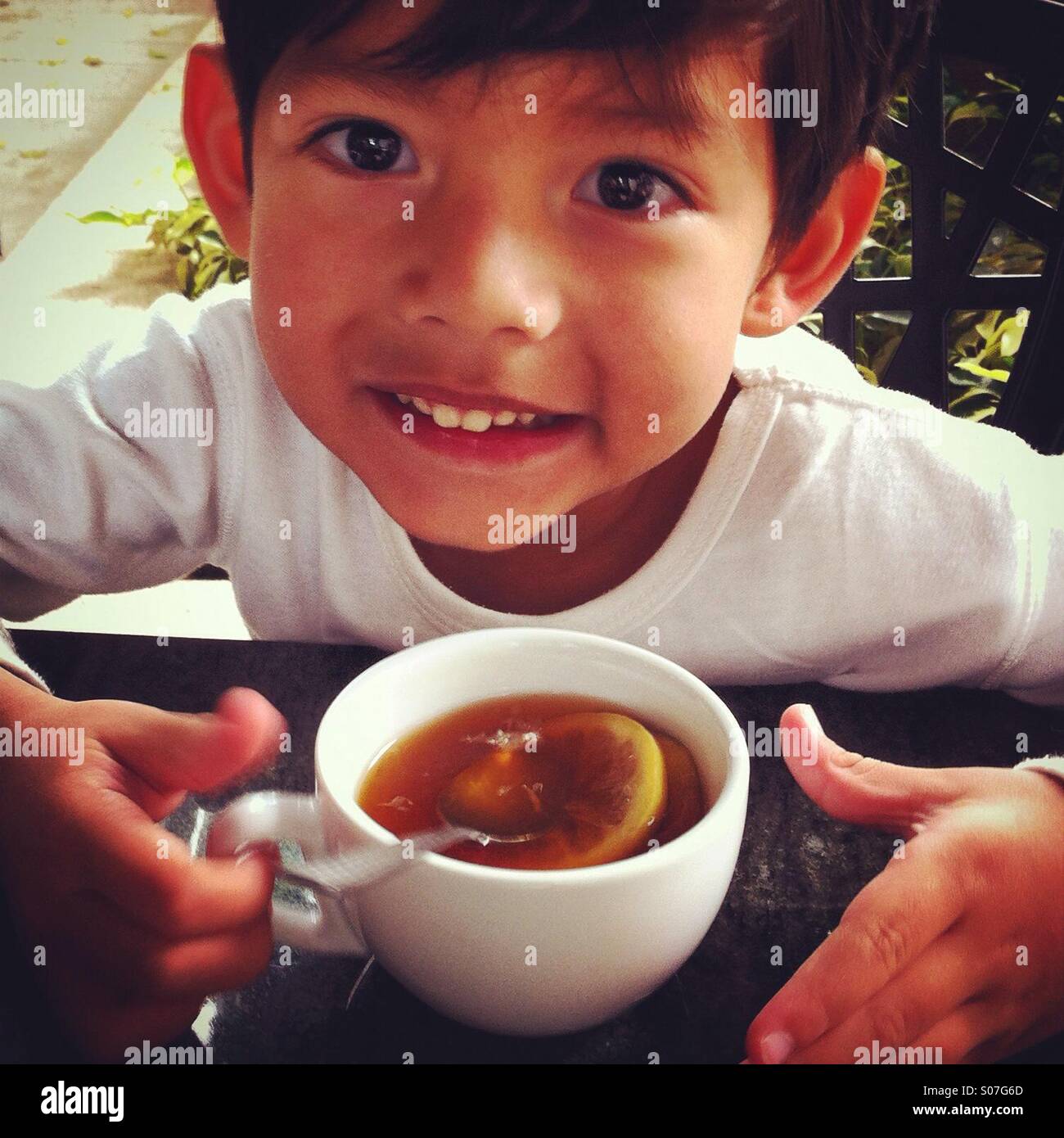 Young kid having a hot lemon tea in Hong Kong Stock Photo