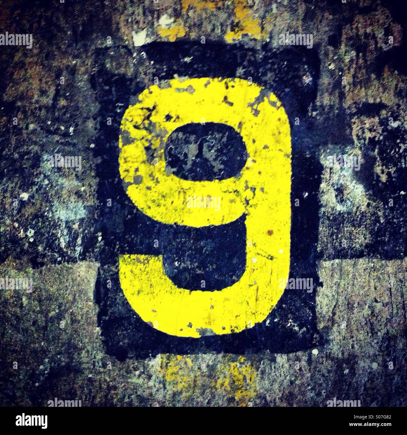 Number 9 in yellow color on a rough ground Stock Photo