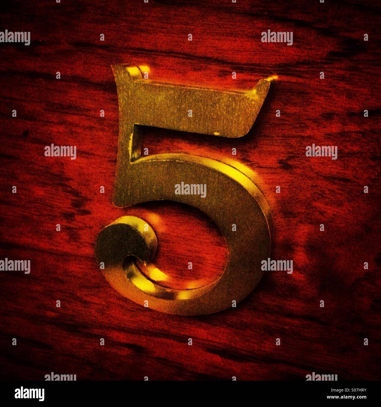 Number 5 in gold color on a wood board Stock Photo