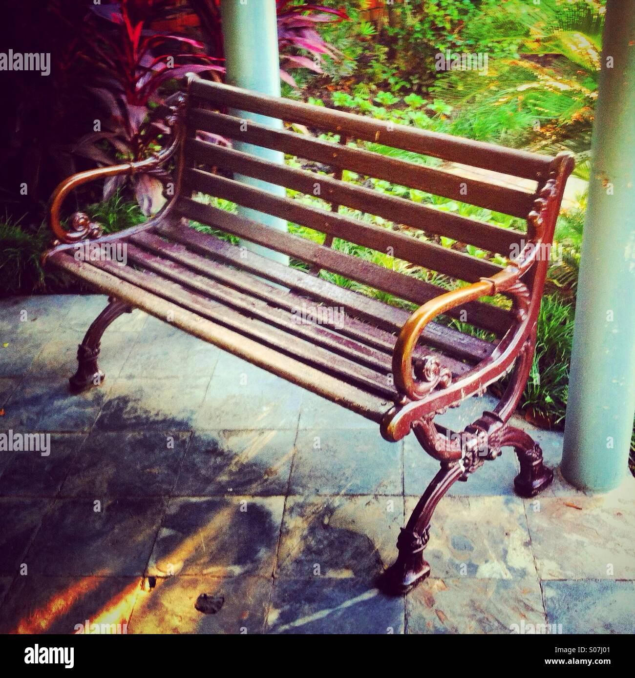 Side view of a wood public bench in a garden - Smartphone Captured Stock Image