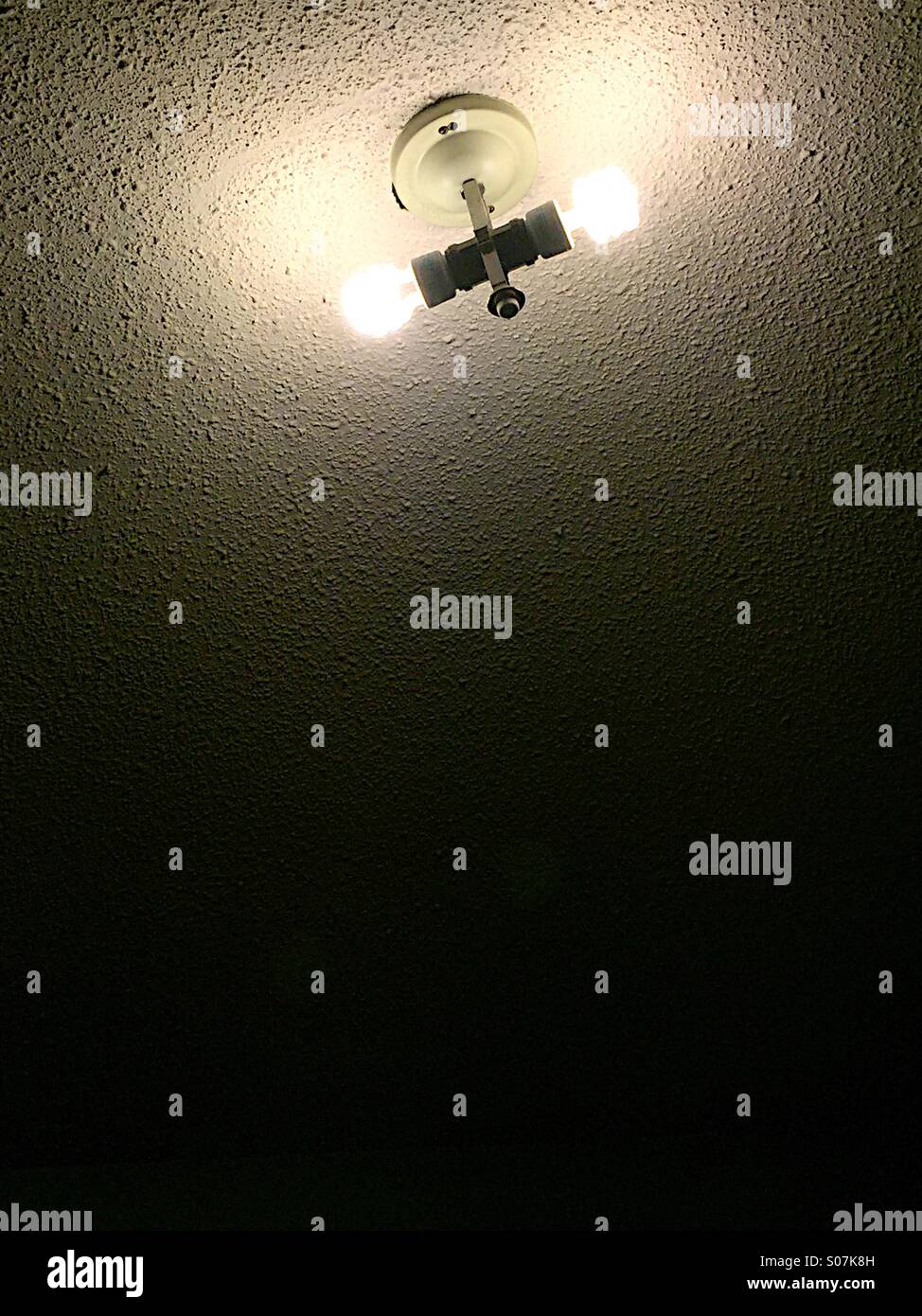 Overhead light bulbs in a dark room. Stock Photo
