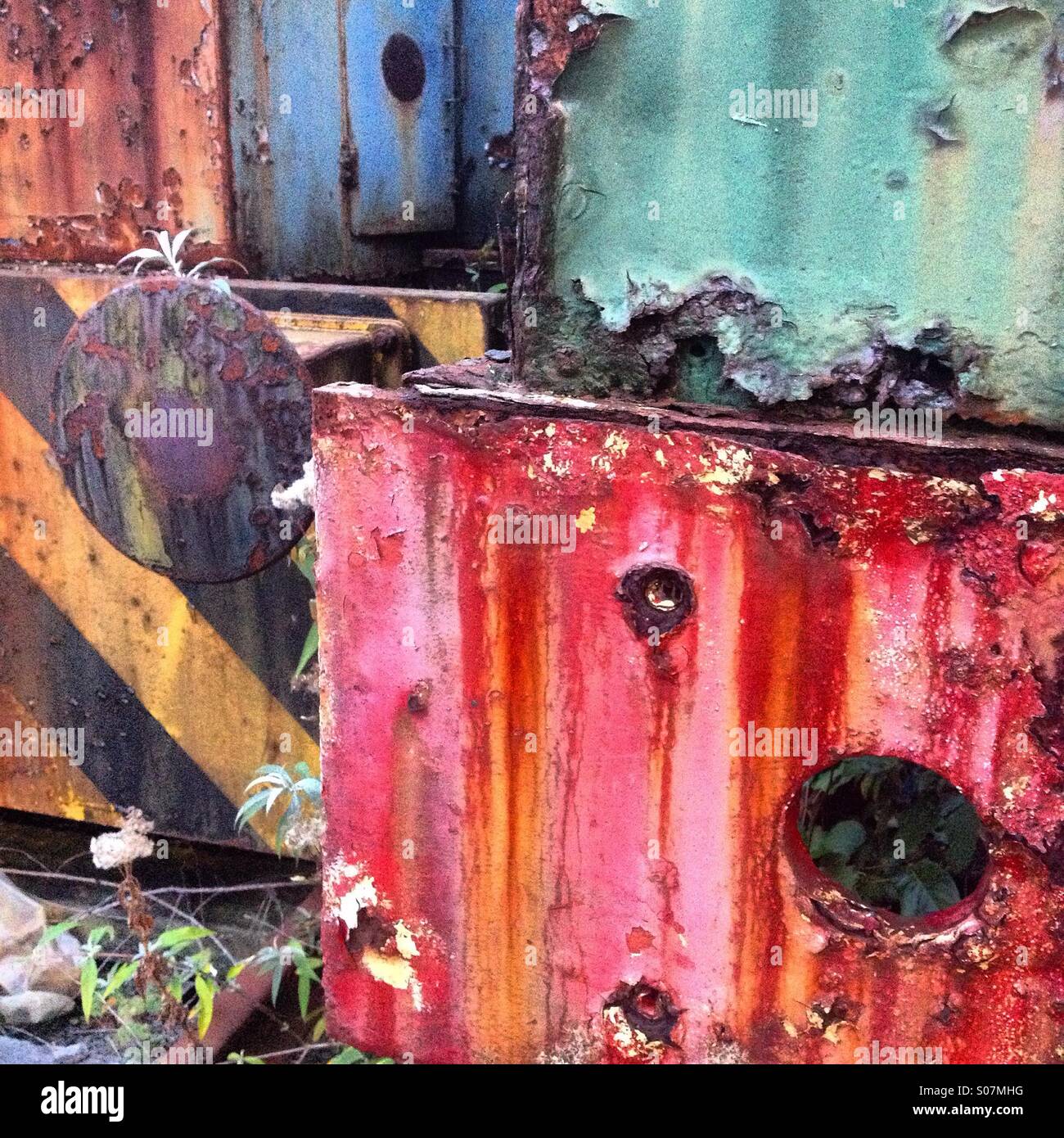 Bits of old brightly coloured painted railway vehicles rusting away abandoned on an old public siding - Smartphone Captured Stock Image