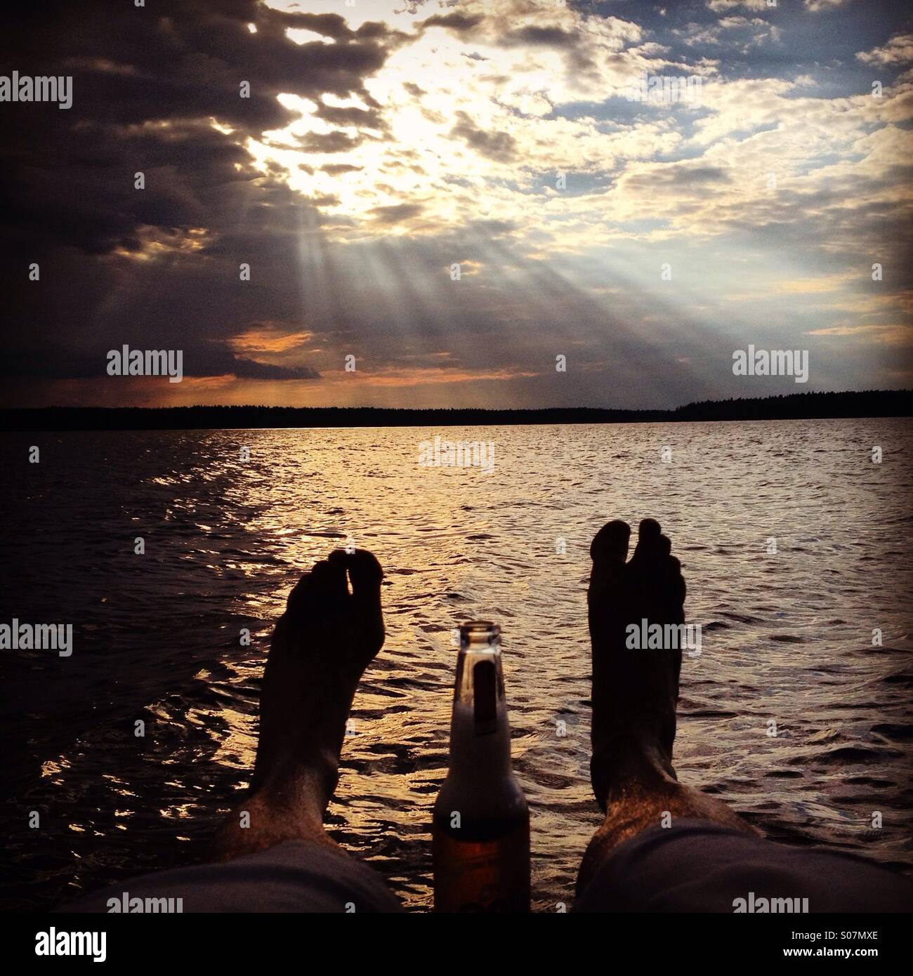 An idyllic evening with a beer at a Nordic summerhouse lake in North Finland - Smartphone Captured Stock Image